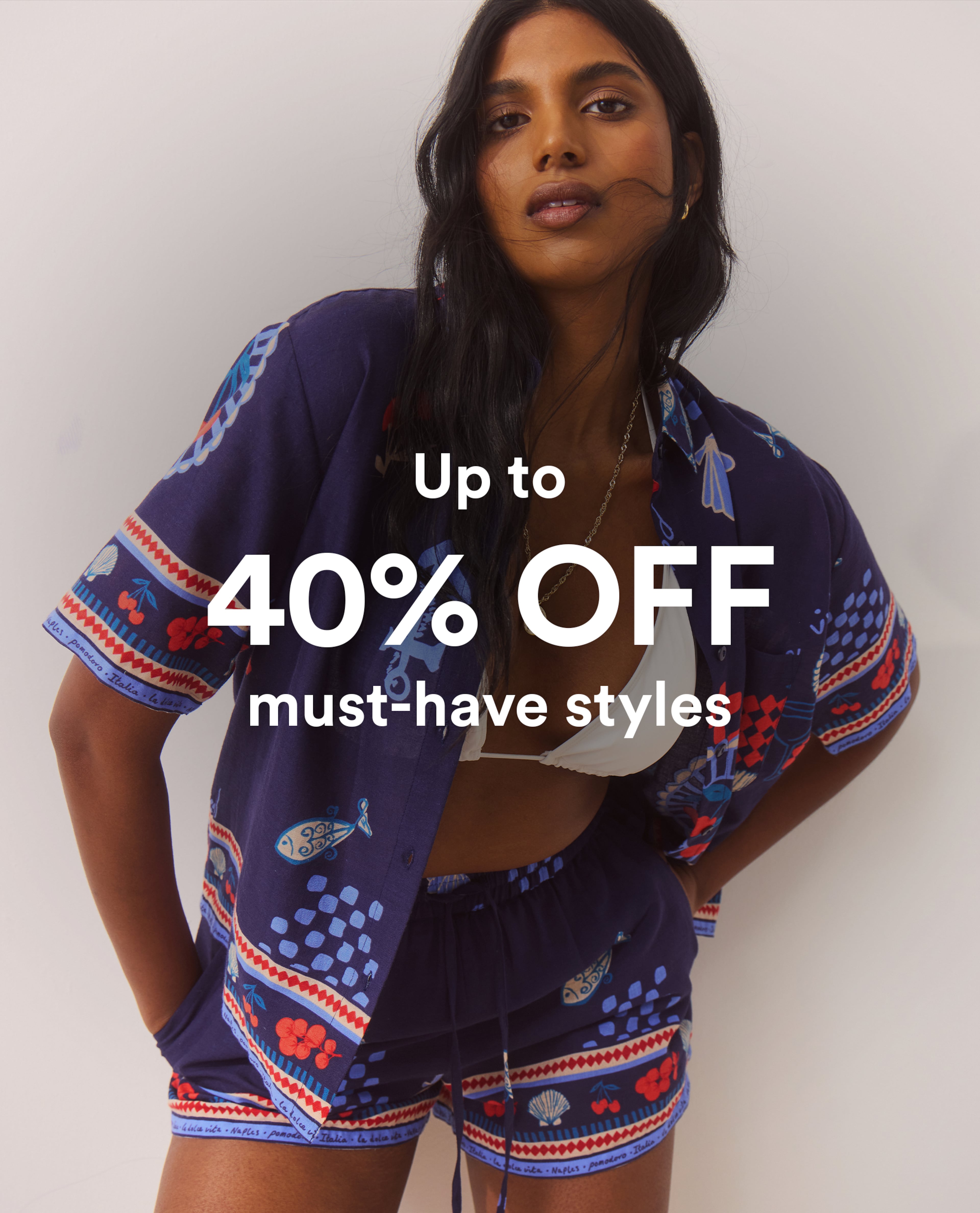 Model wearing a blue printed co-ord over a white bikini top with a 40percent off promotion.