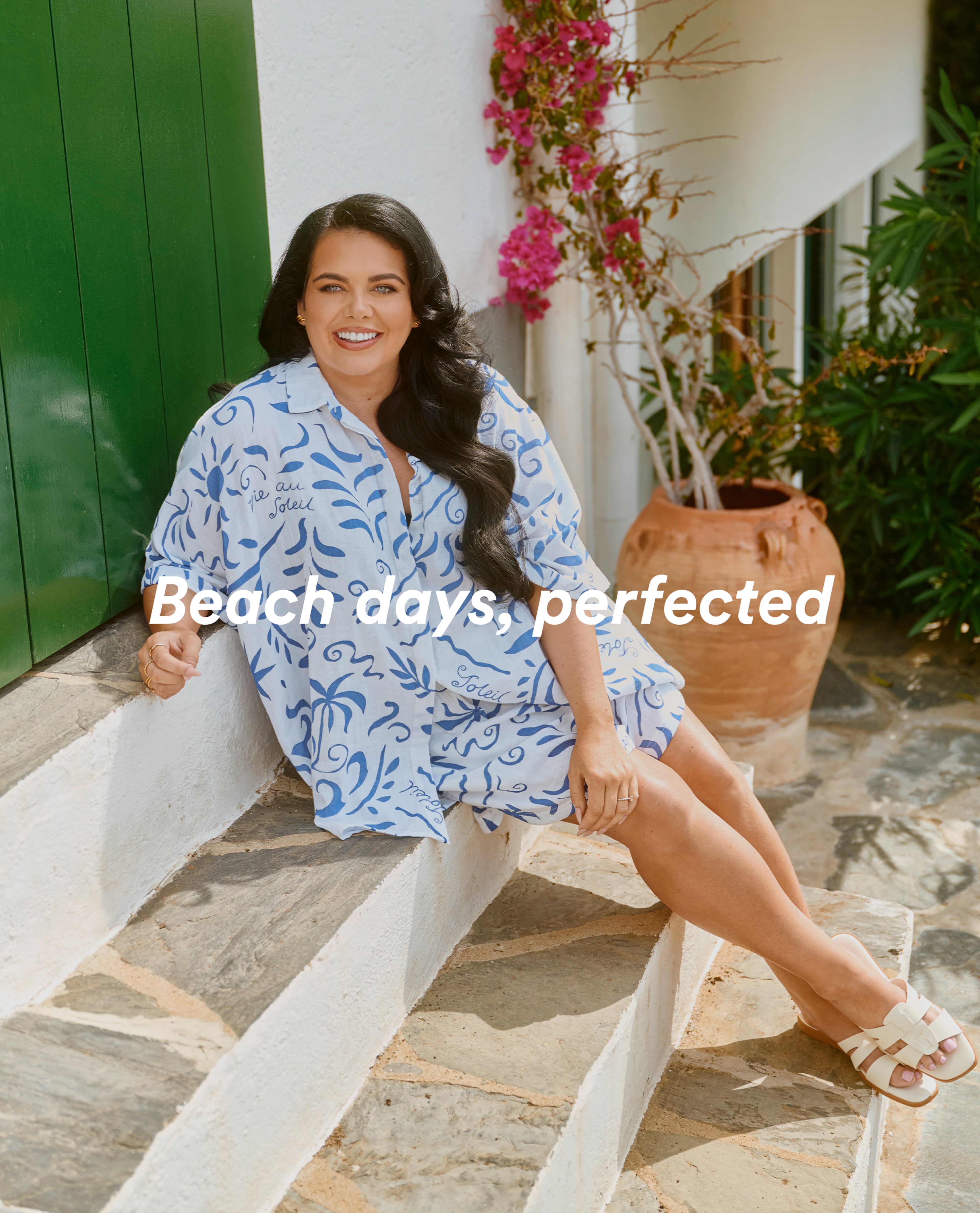 Person seated on stone steps wearing a loose blue-and-white printed outfit and sandals, with text reading “Beach days, perfected.”