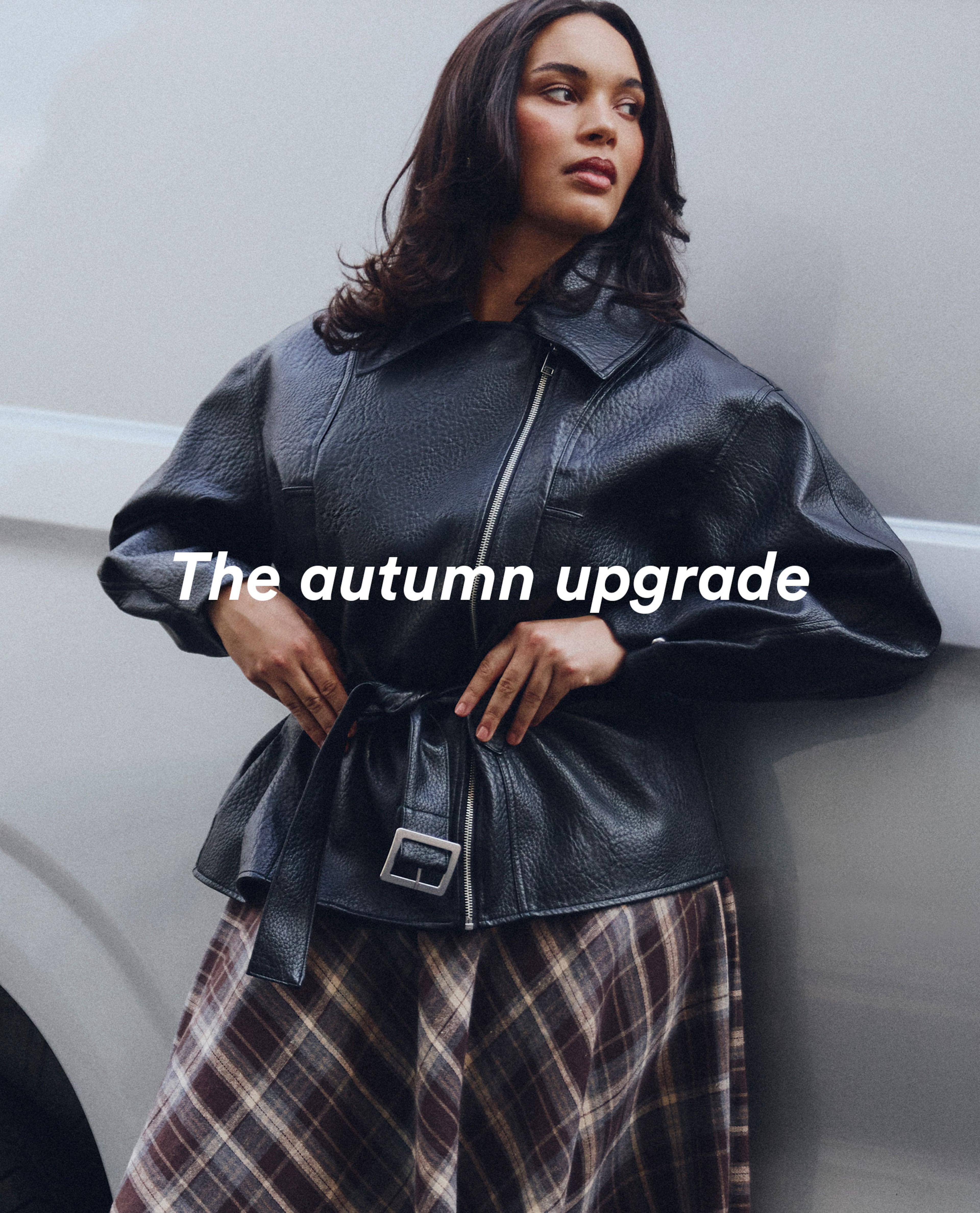 model wearing black leather jacket next to white van