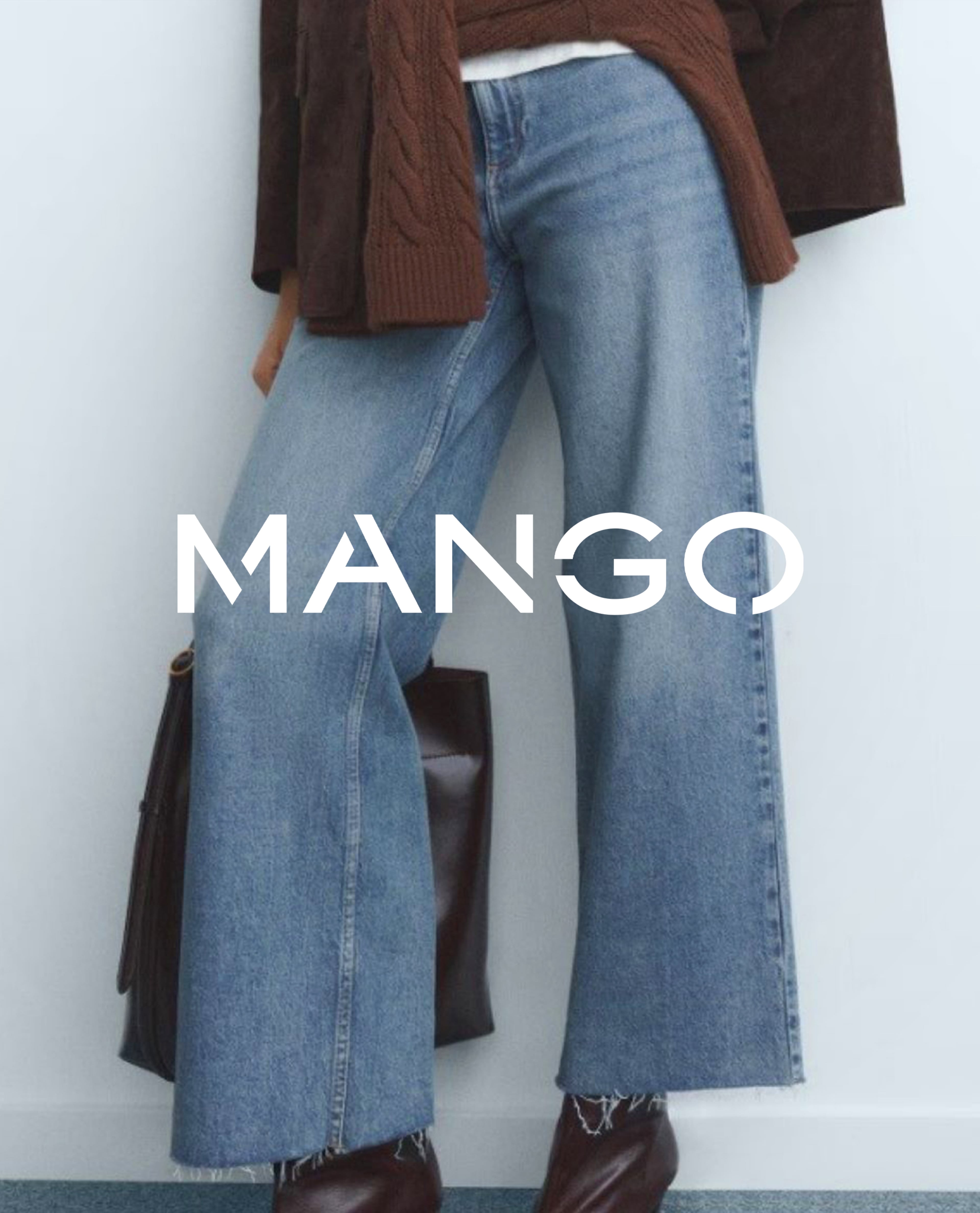 Close-up of light blue wide-leg jeans styled with brown knitwear and boots.