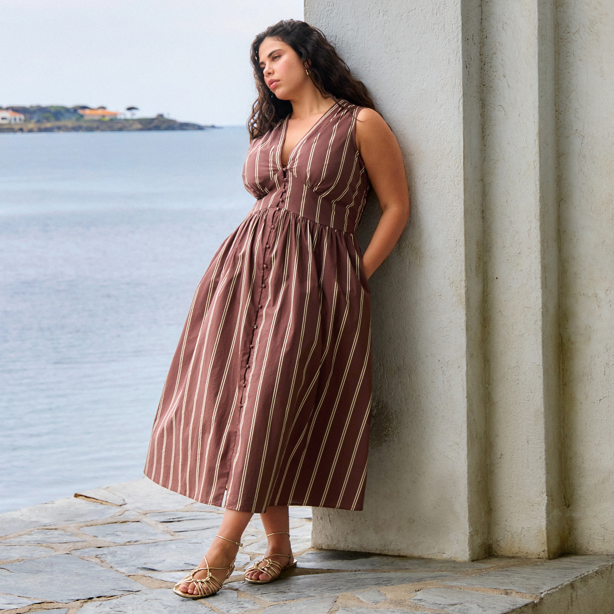 Model wears pinstripe dress in brown