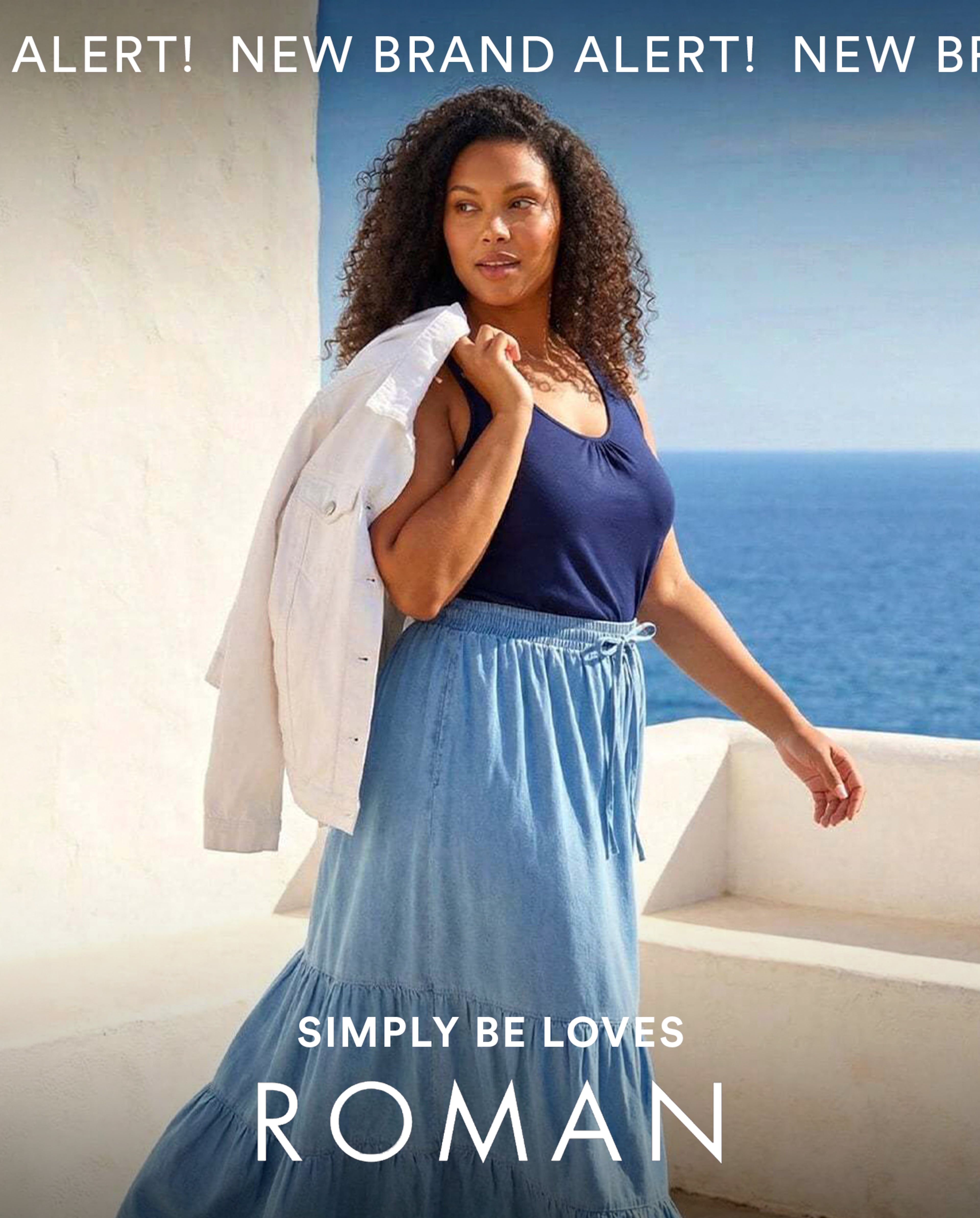 Person walking beside a white wall overlooking the sea, wearing a navy top and blue skirt with a white jacket over the shoulder; text reads “SIMPLY BE LOVES ROMAN.”