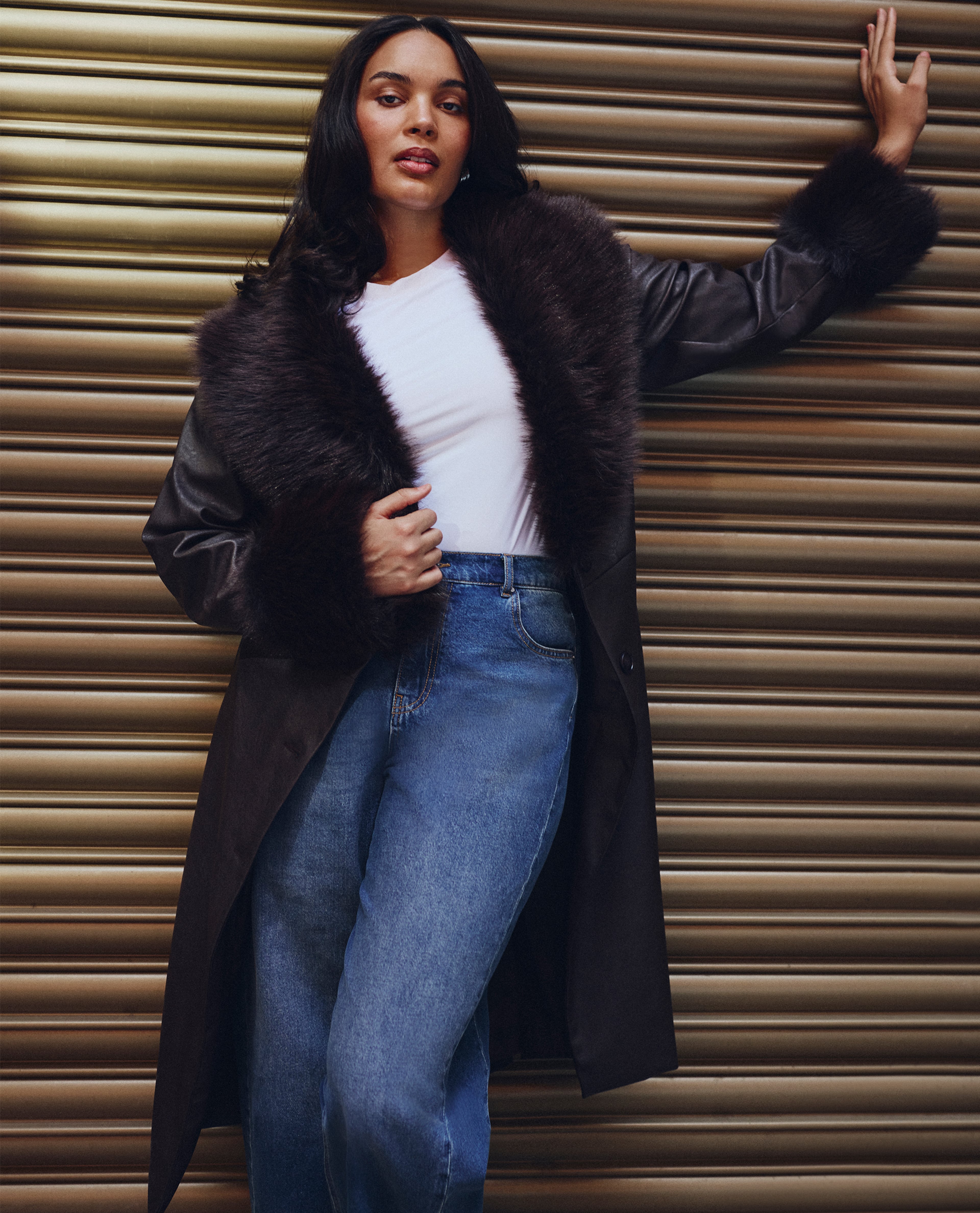 Model wears faux-fur trim coat and jeans