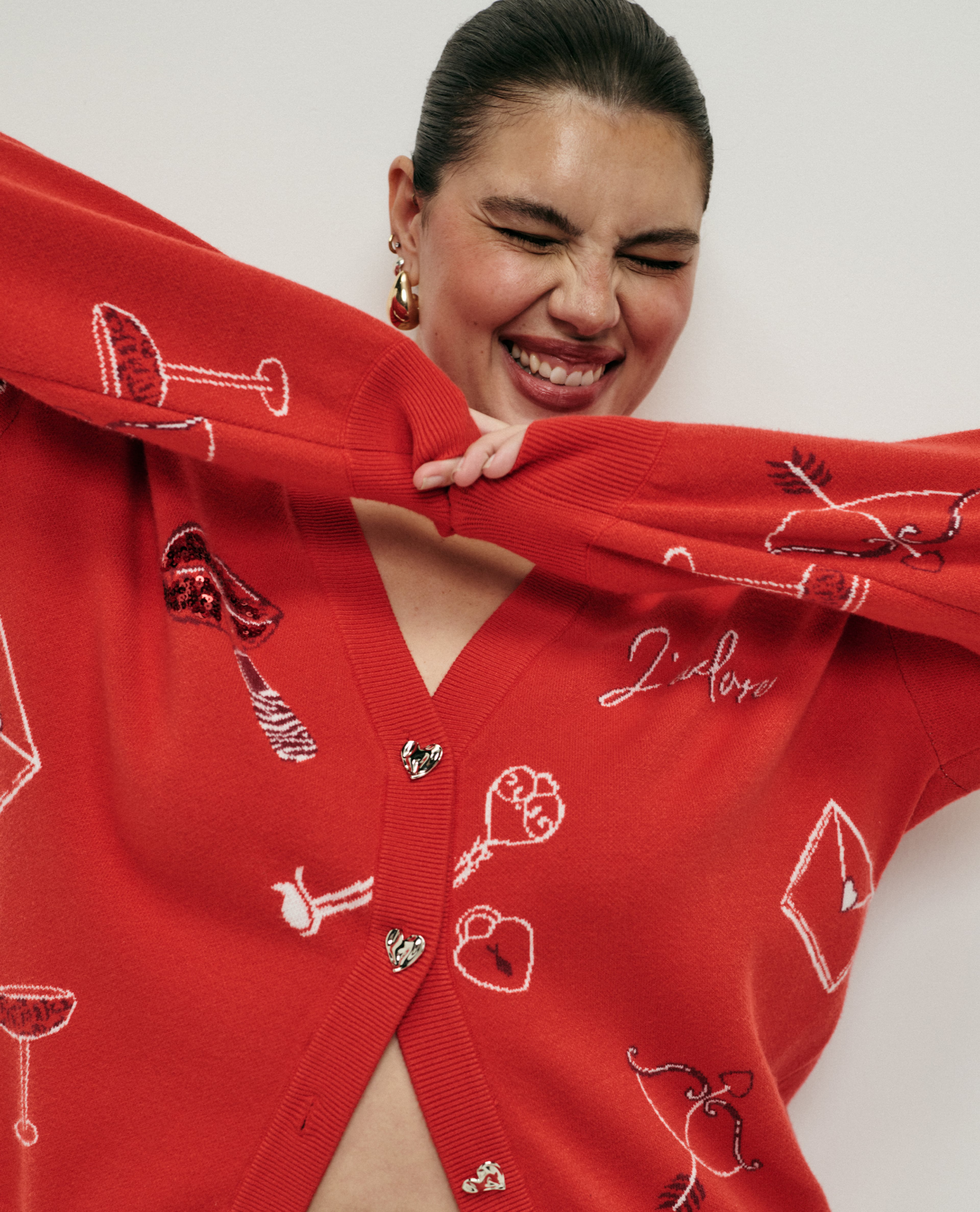 model wearing red xmas bright jumper arms together in the middle