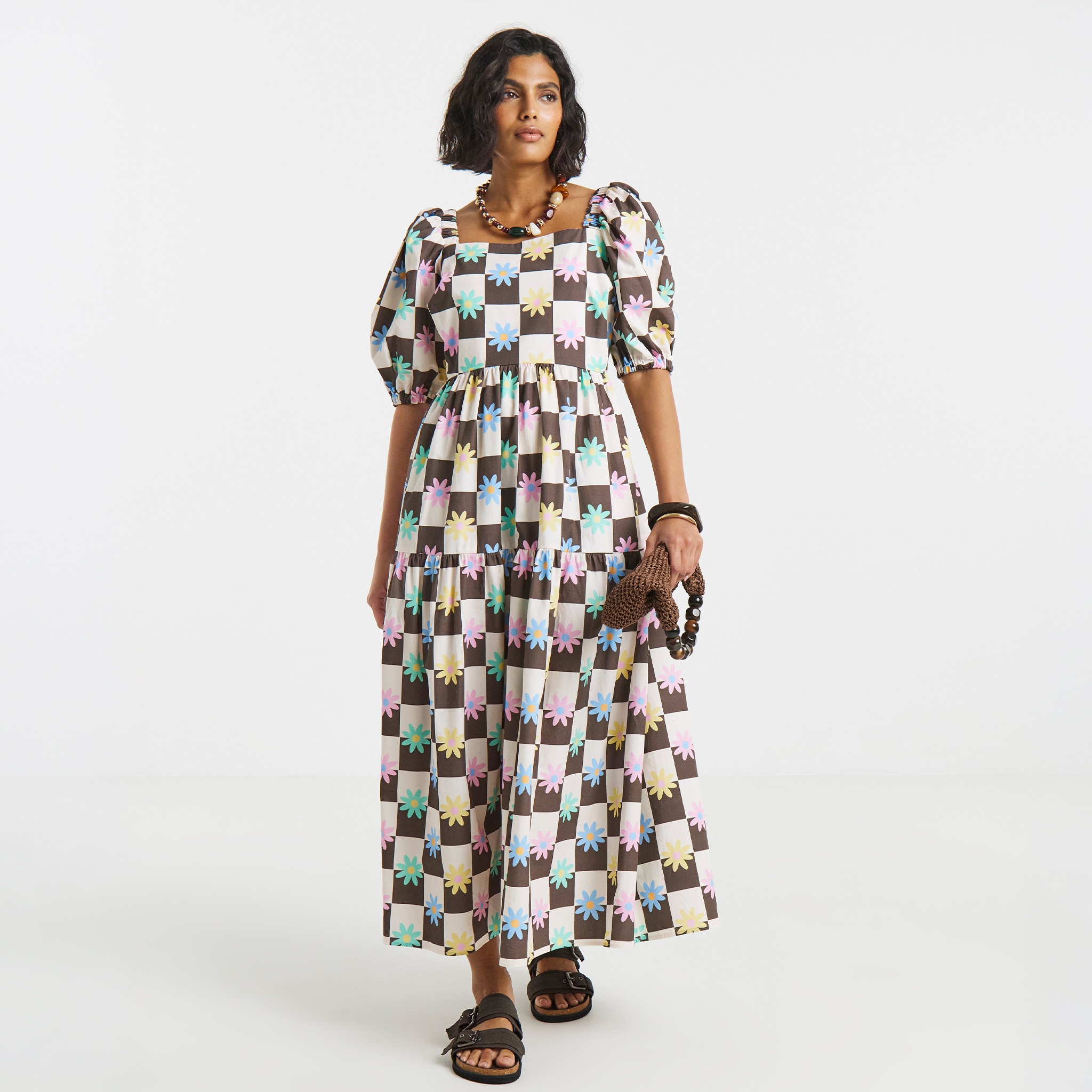 model wearing long dress carrying bag