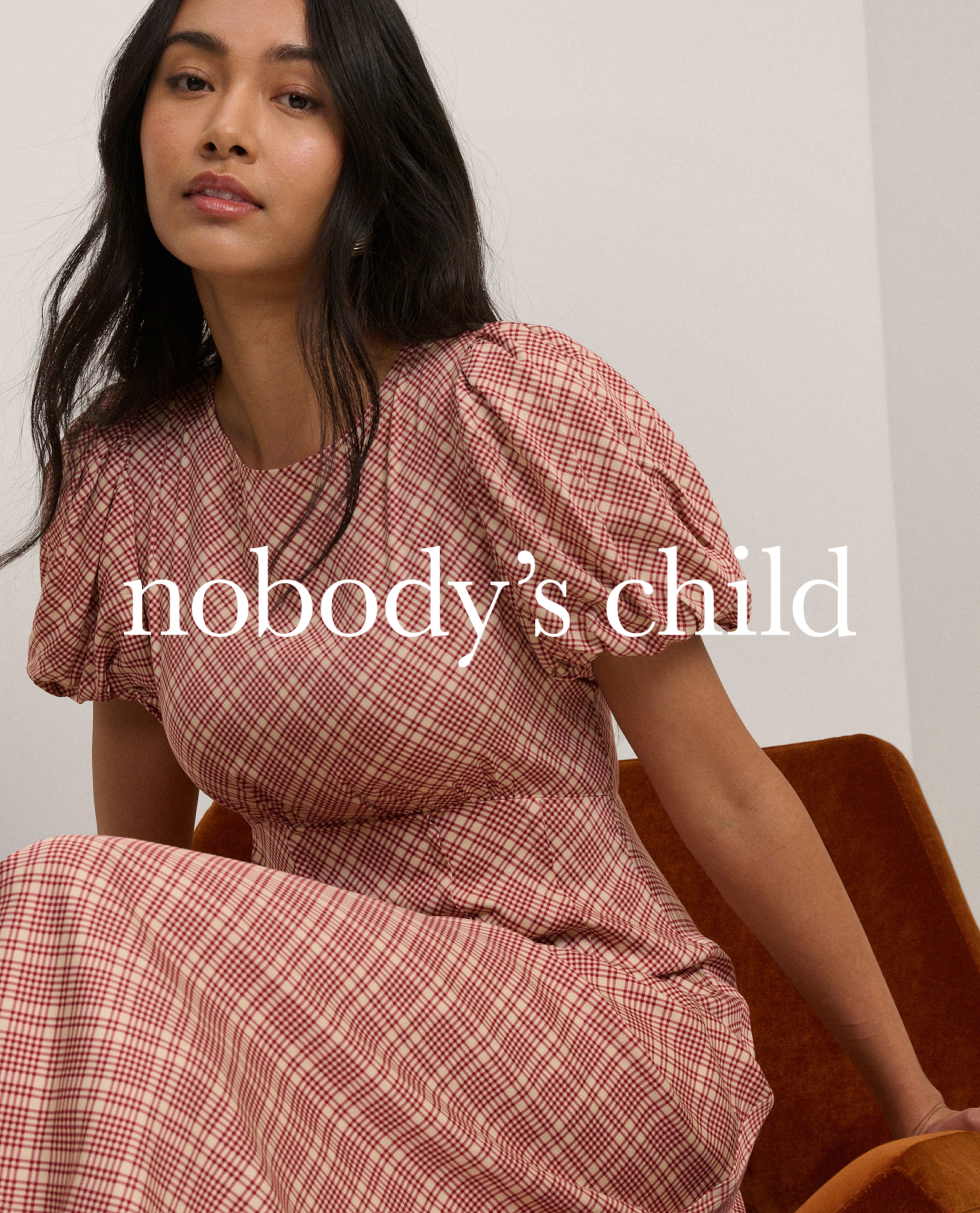 Model wears check print dress from Nobody's Child