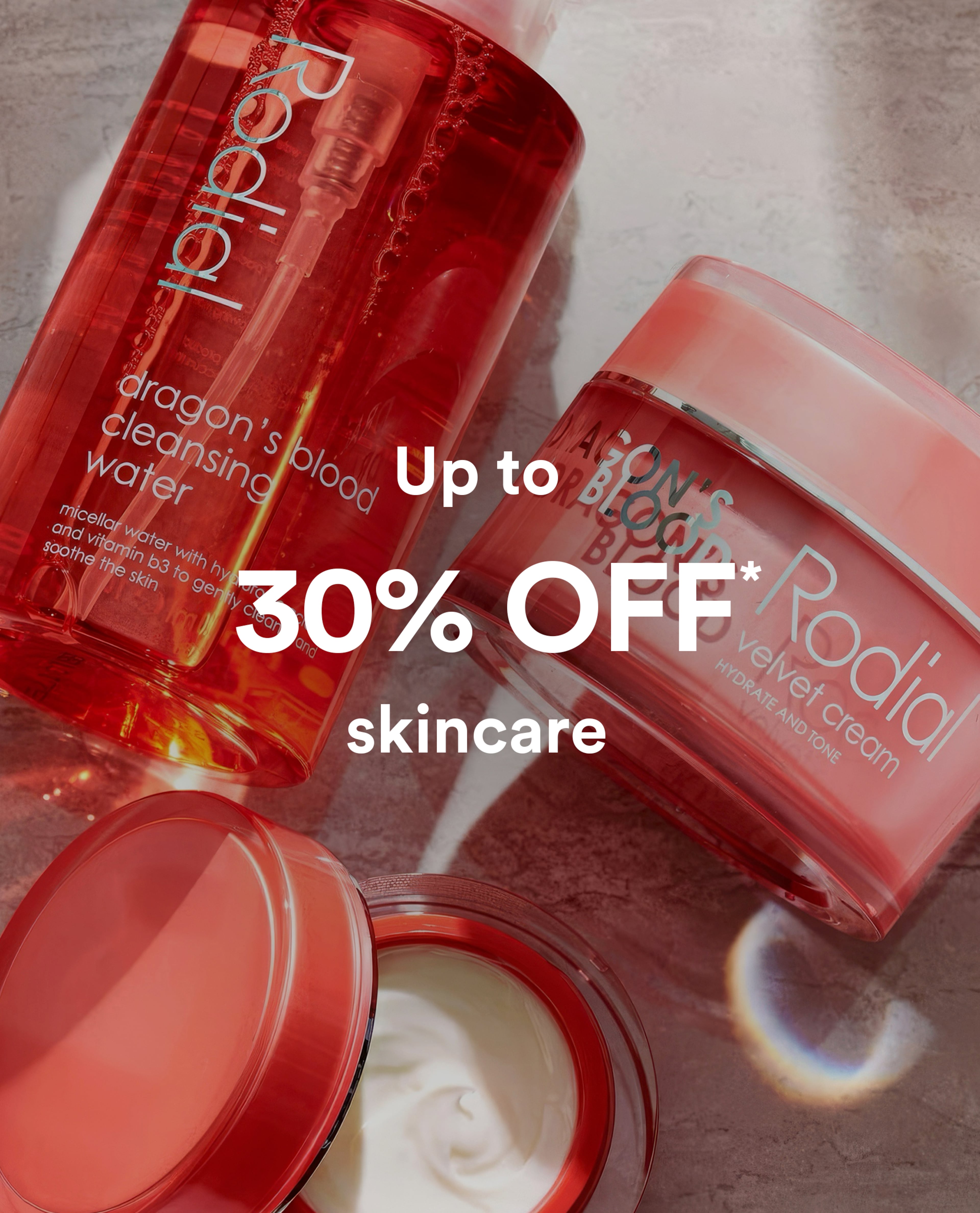 Red skincare products arranged on a textured surface, including cleansing water and cream jars, with text reading “Up to 30% OFF skincare.”