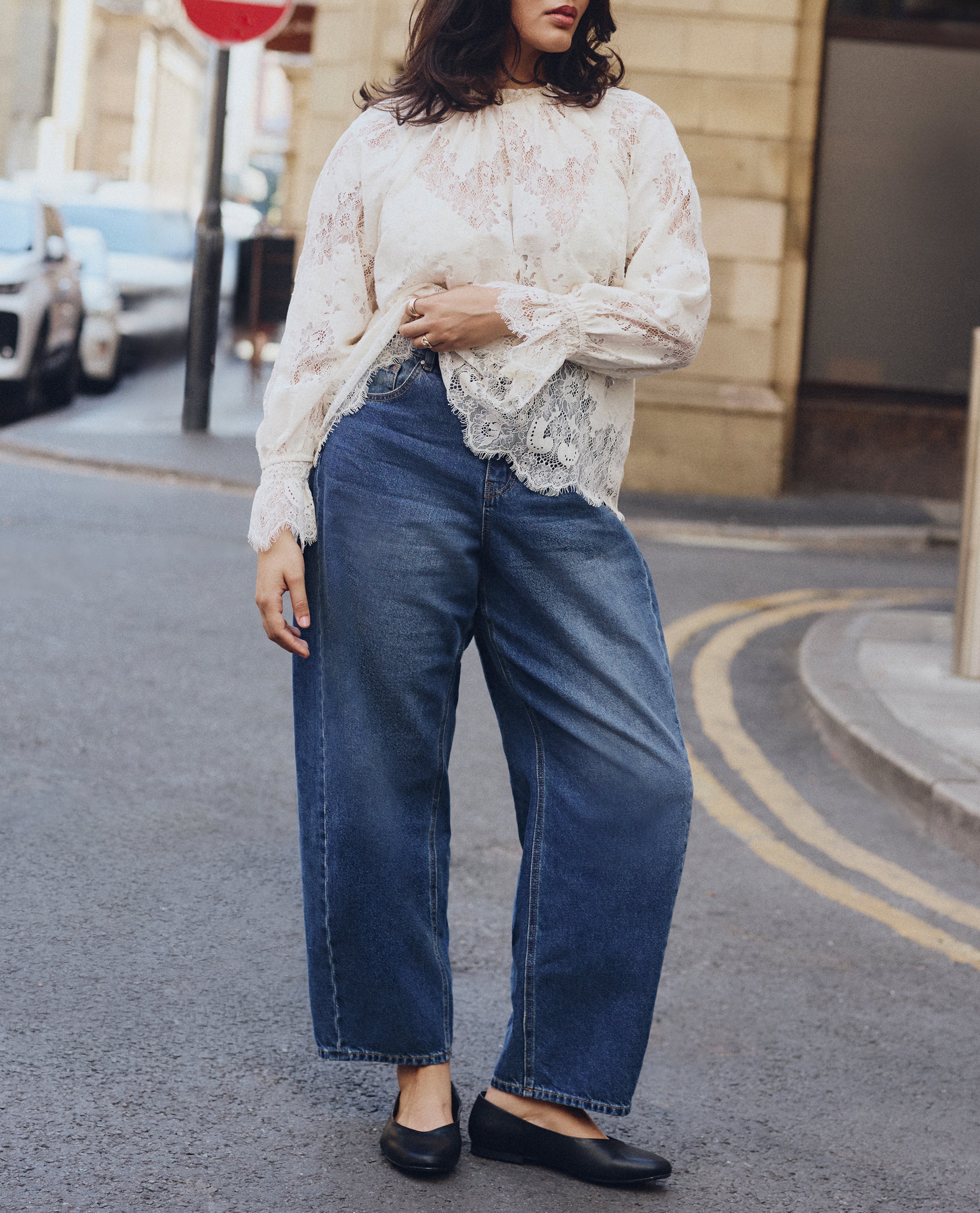 Model wears blue jeans and crochet top