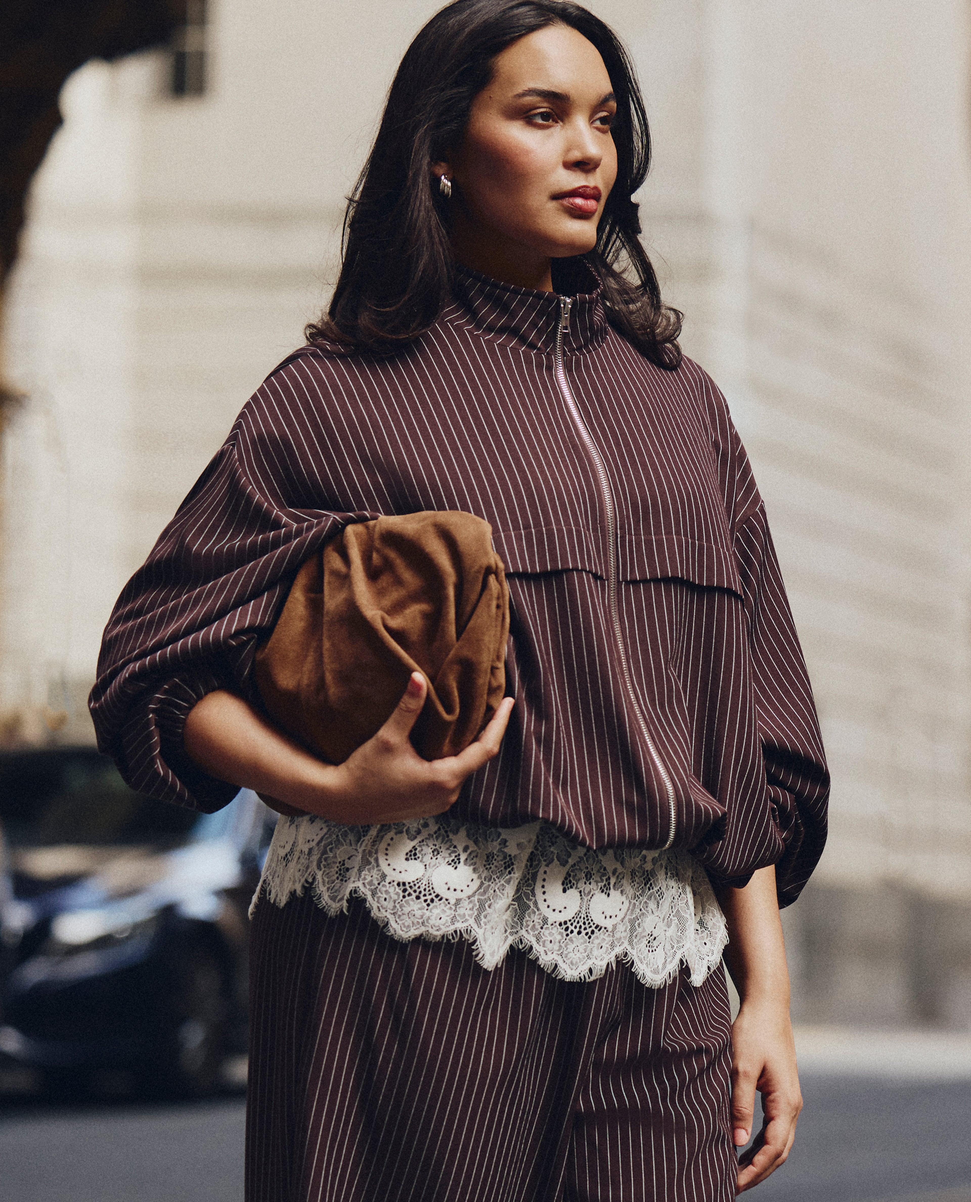 model wearing pin strip brown coat holding bag