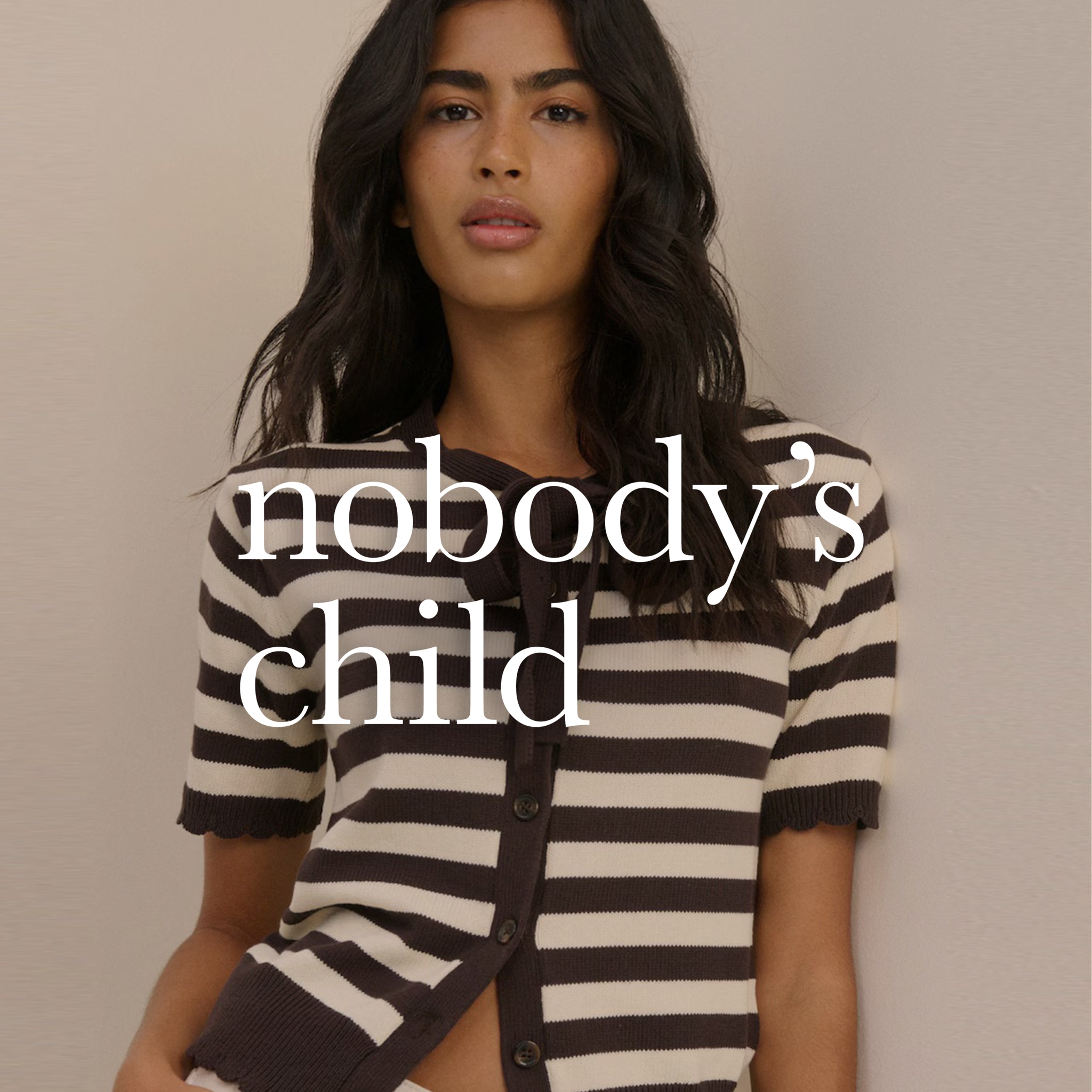 Model is wearing a Nobody's Child short sleeve tie neck cardi.