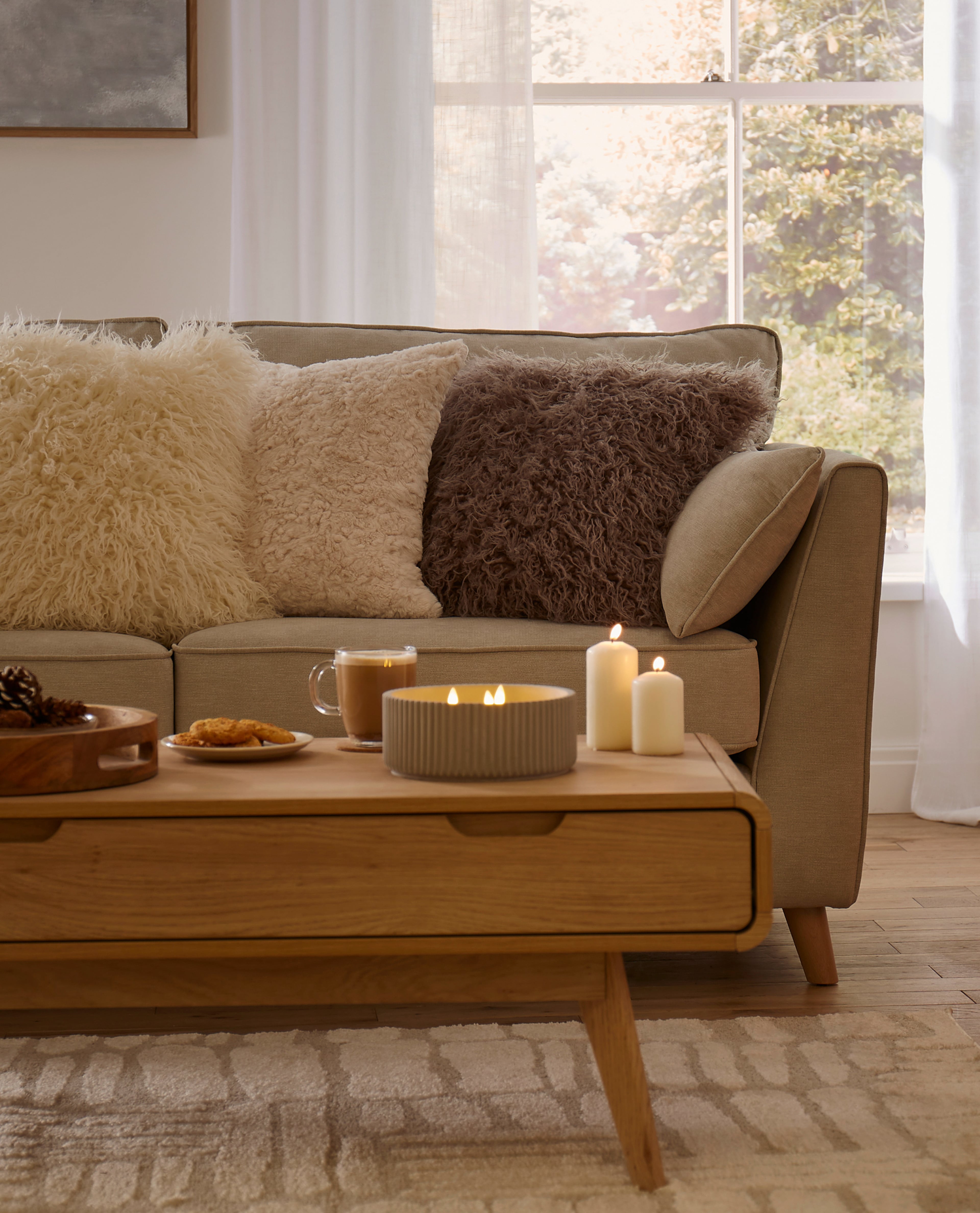 living room setting with sofa, cushions and candela