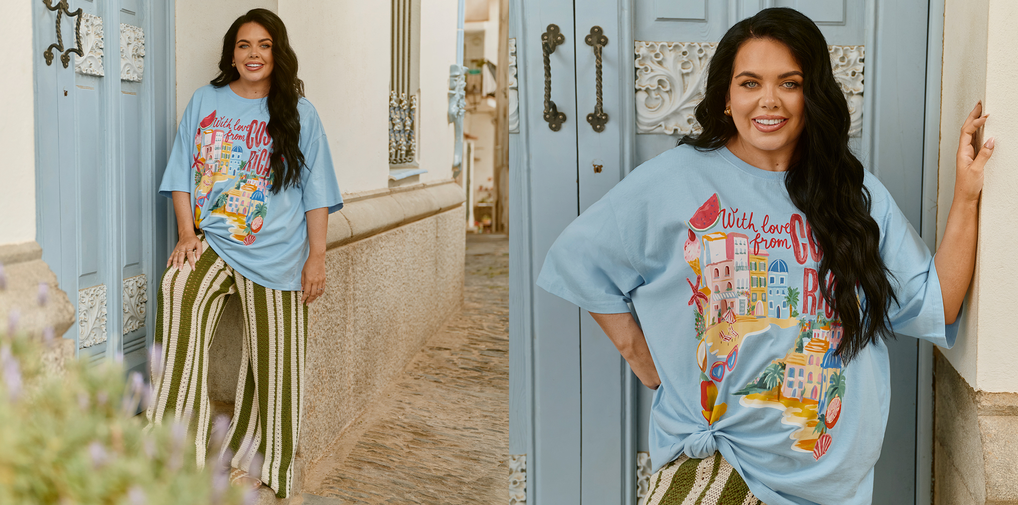 Person wearing a light blue graphic T‑shirt and striped wide‑leg trousers, standing on a cobblestone street beside pale blue doors.