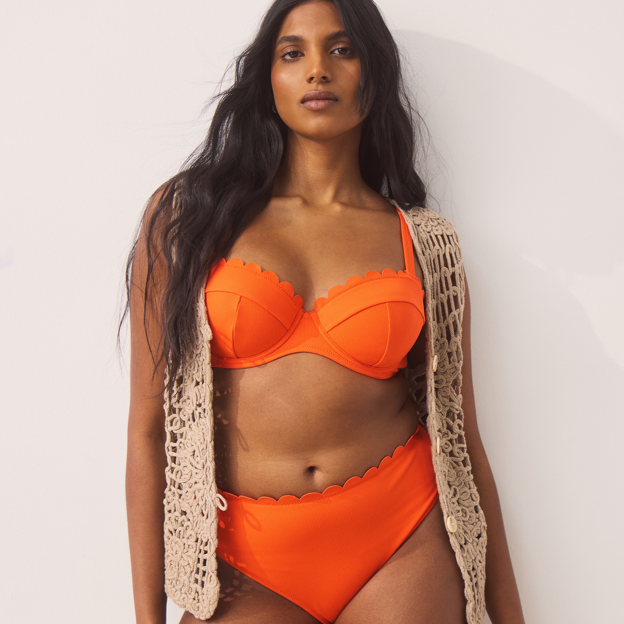 model wearing orange swimsuit