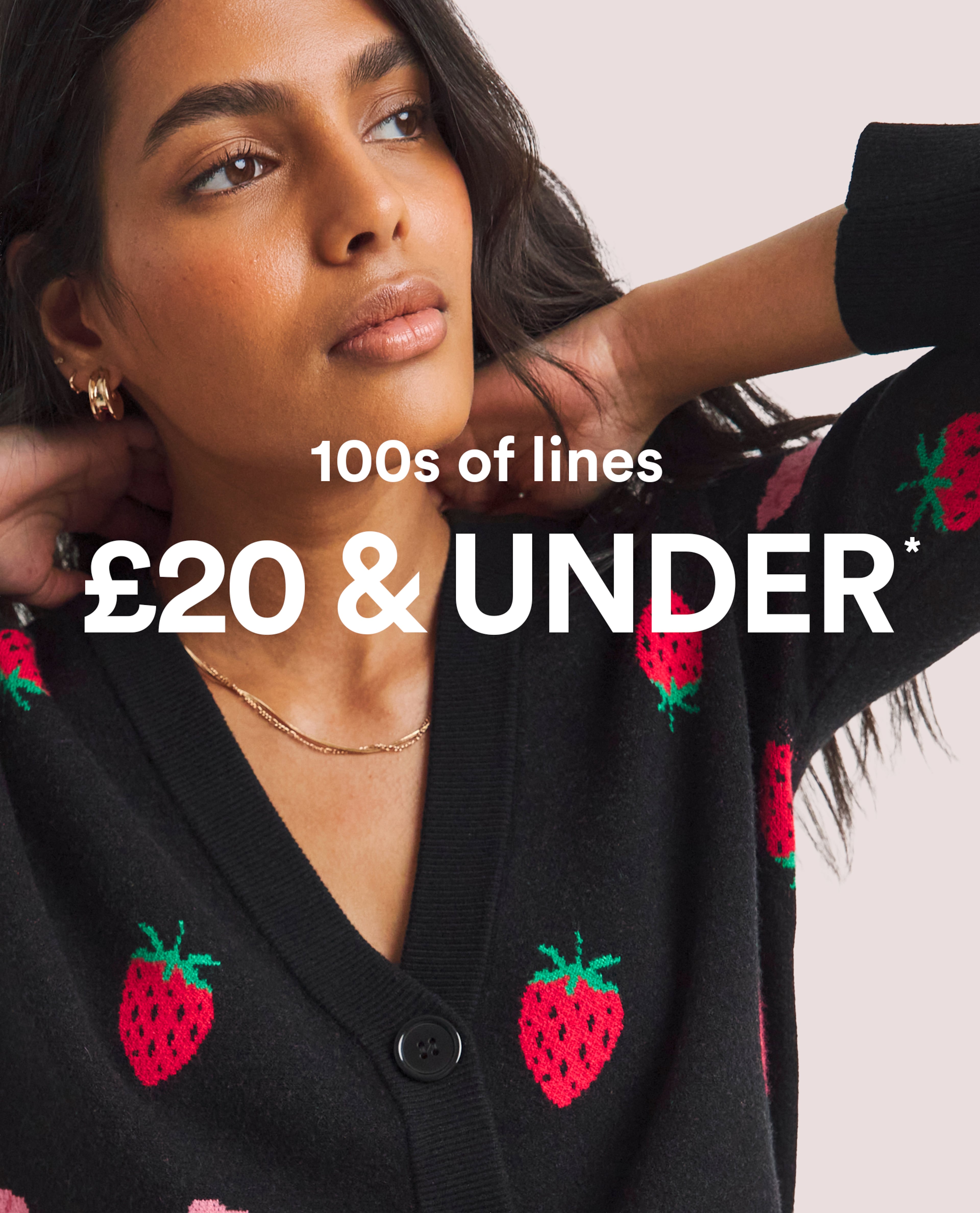 Model wearing a black cardigan with red strawberry pattern