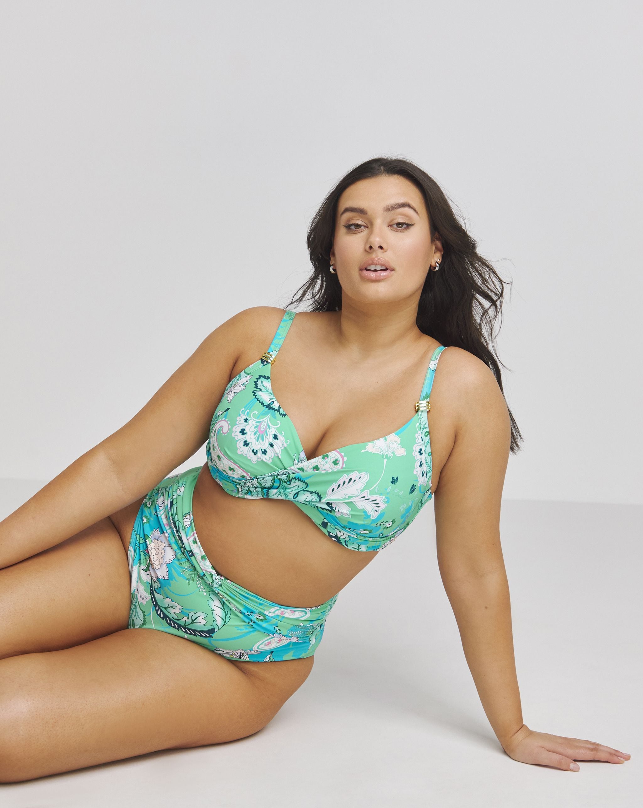 Model sat wearing a green bikini