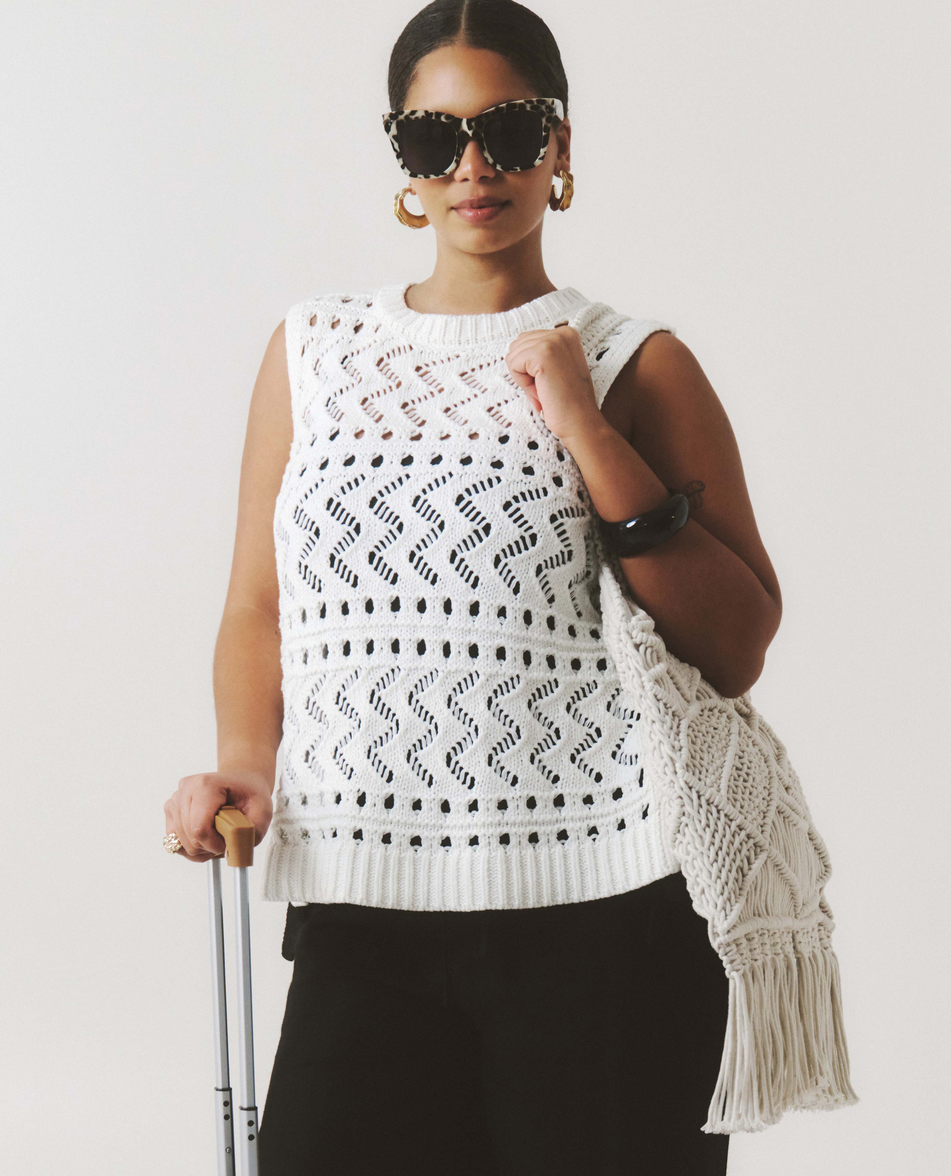 Model wears crochet sleeveless top and sunglasses