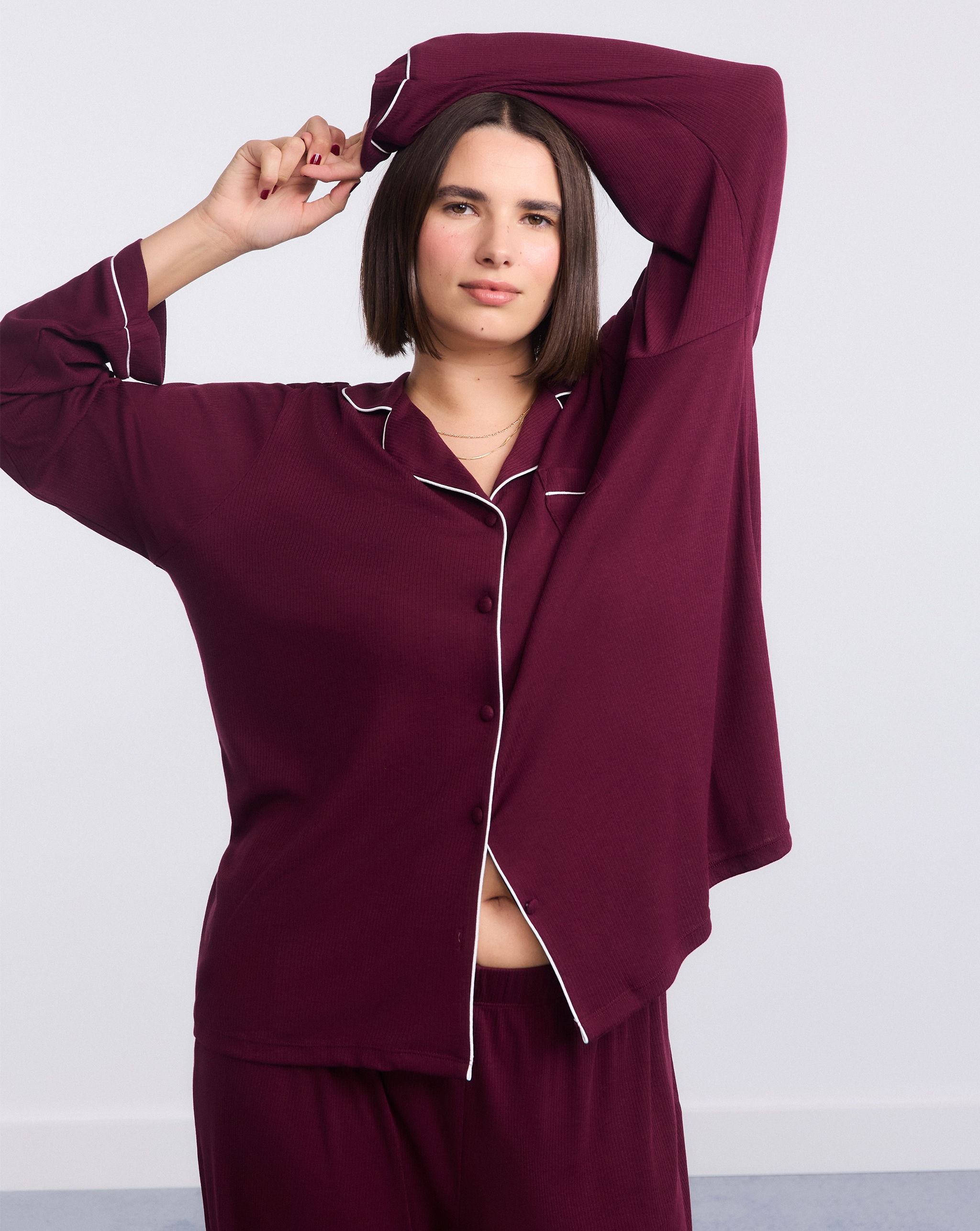 Model wears pyjama set in deep red