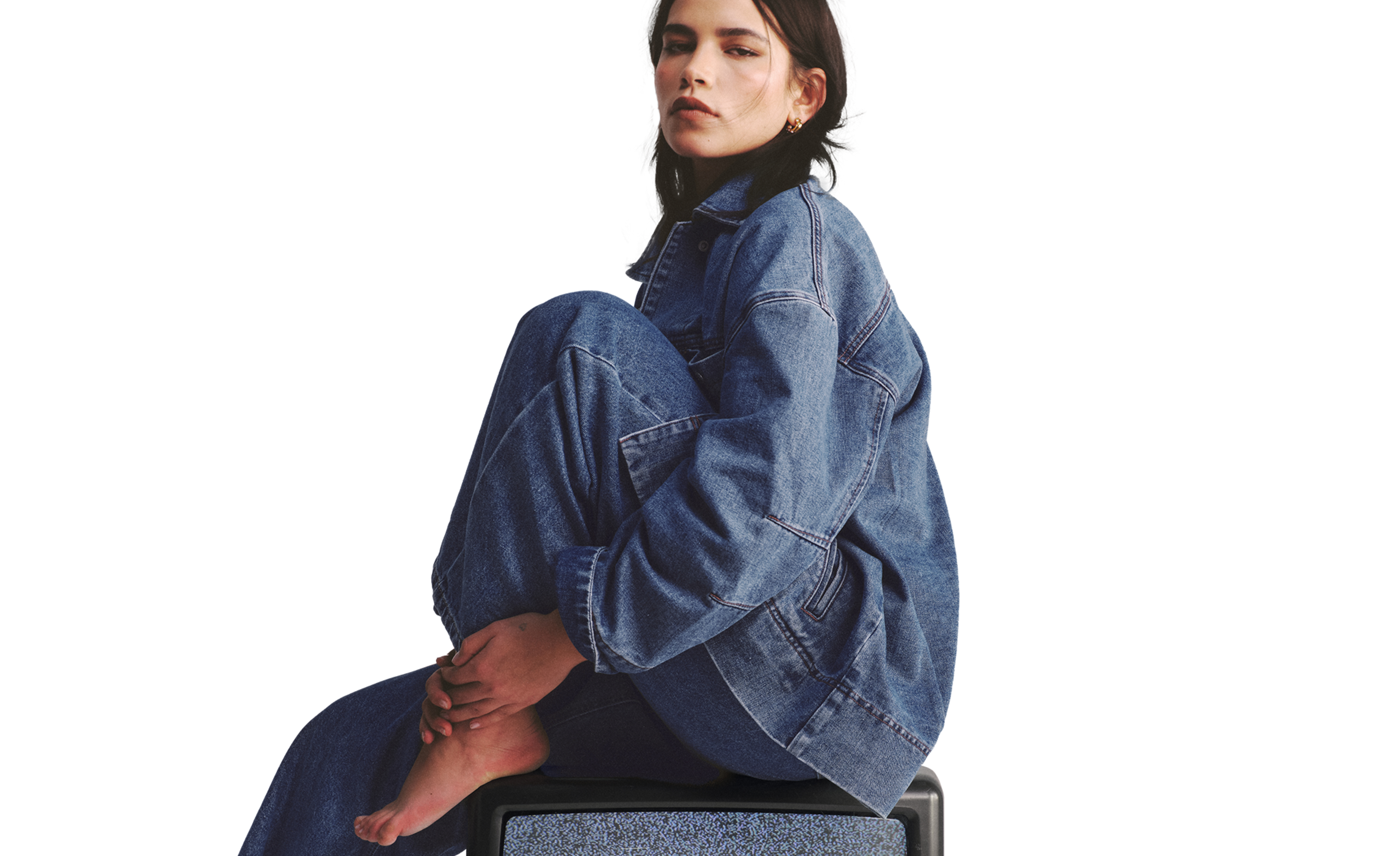 Model wears denim shirt and jeans
