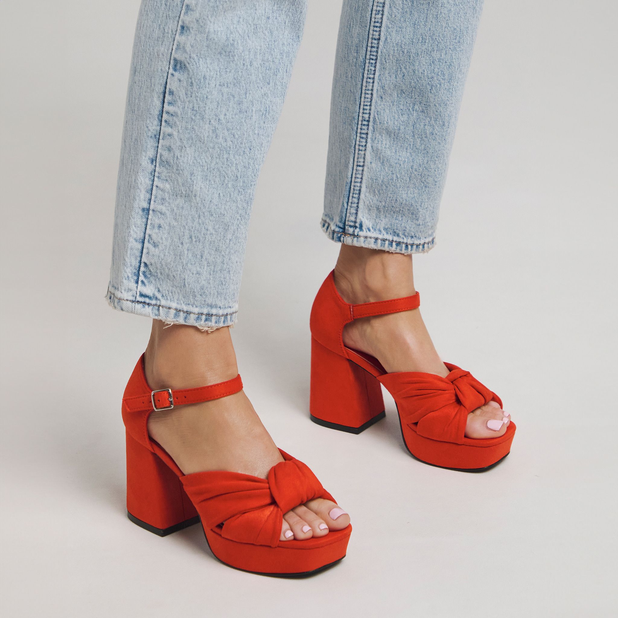 Woman wearing red bow styled wedge heels