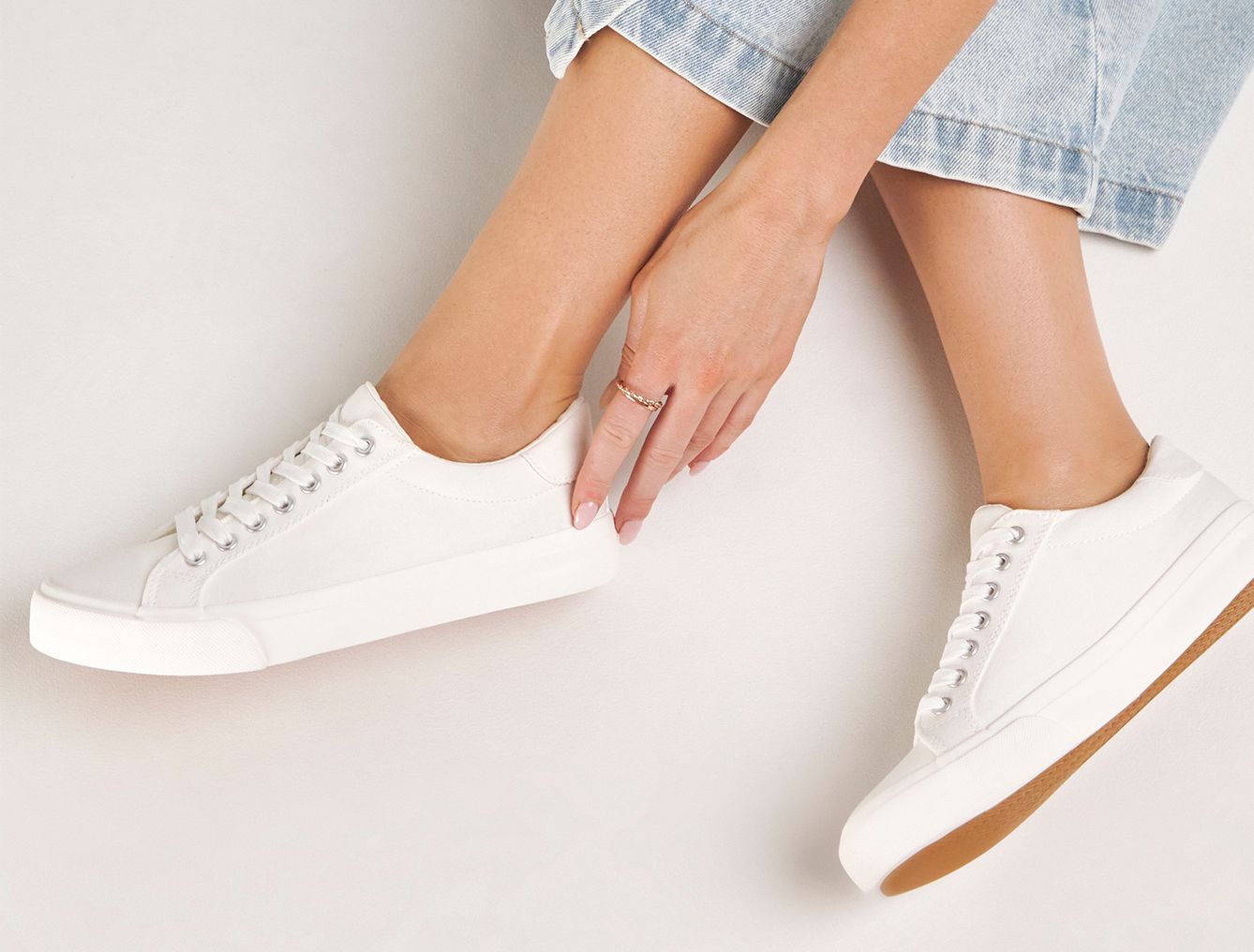 Model is wearing a pair of white Busselton lace up leisure pumps