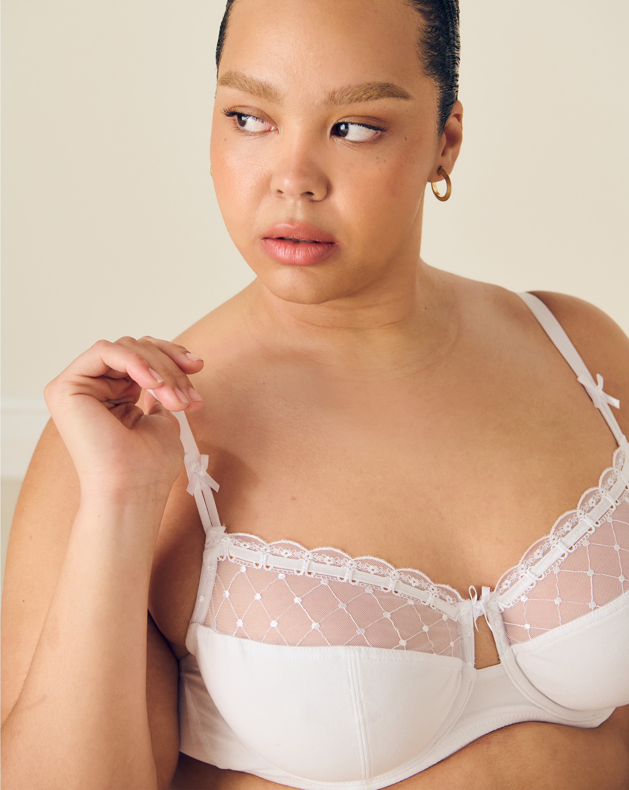 Model wears white bra with lace detail
