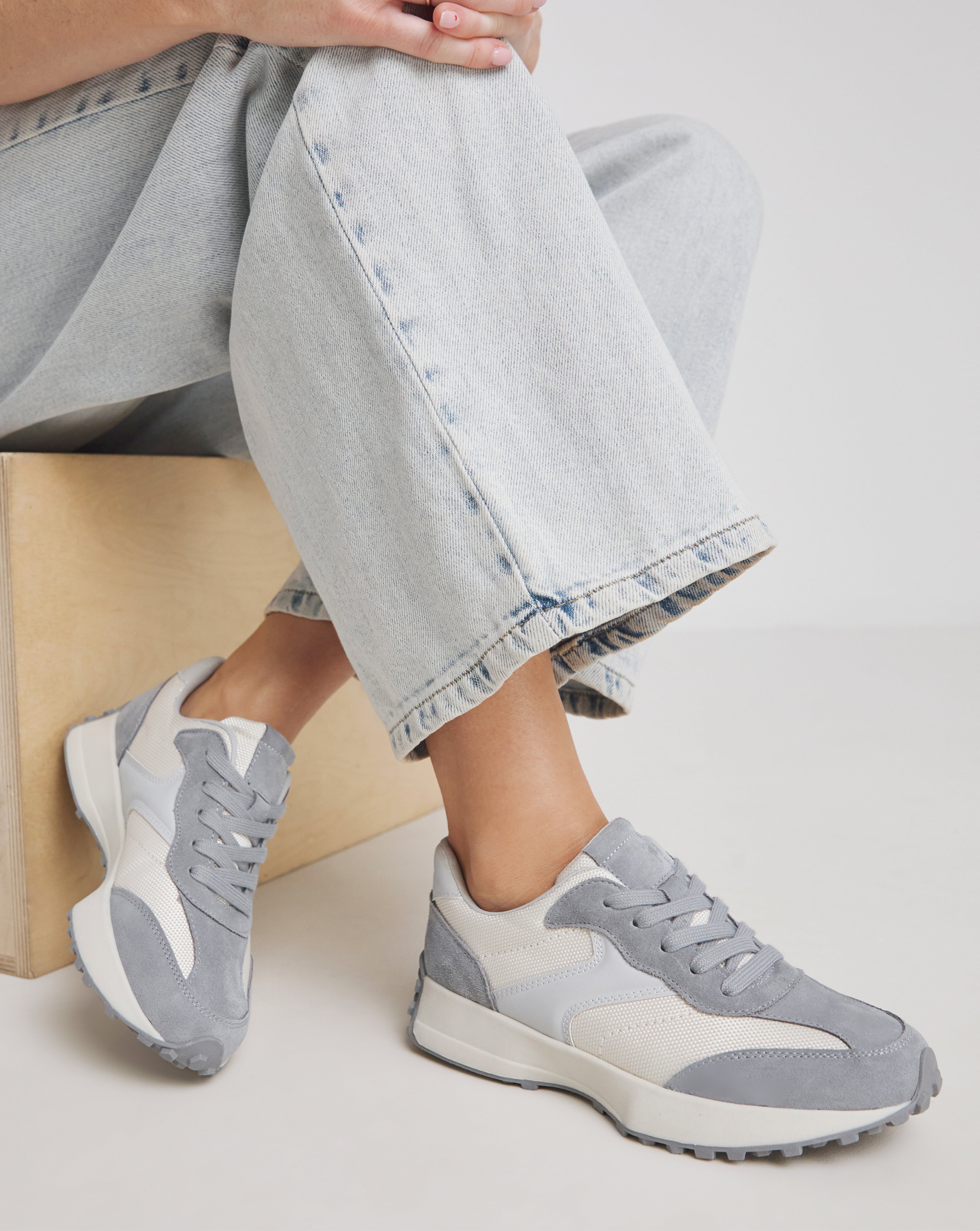 Model wears grey and white trainers