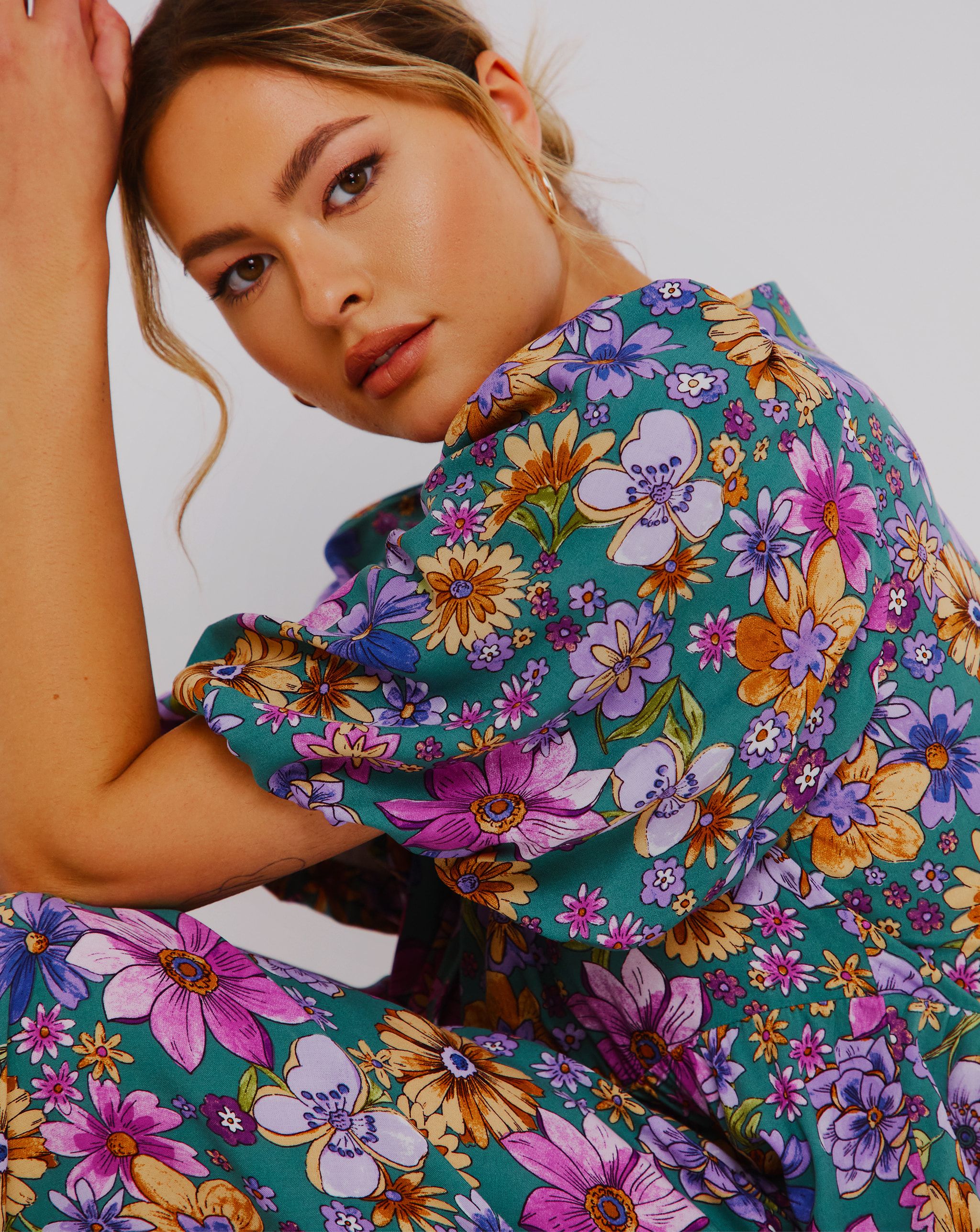 a woman wearing a multi coloured flowery dress
