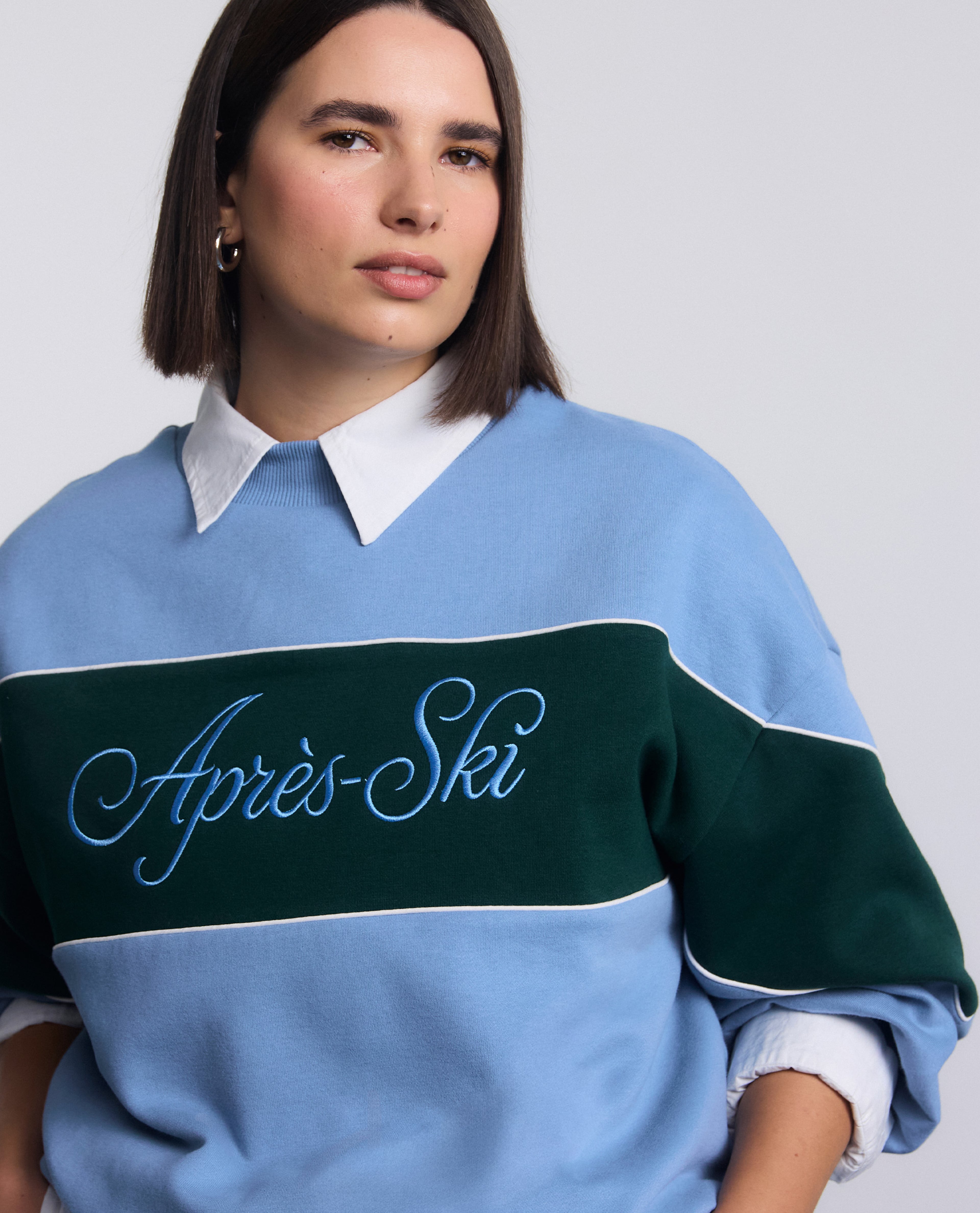Model wearing Simply Be Blue Apres Ski Graphic High Neck Sweatshirt