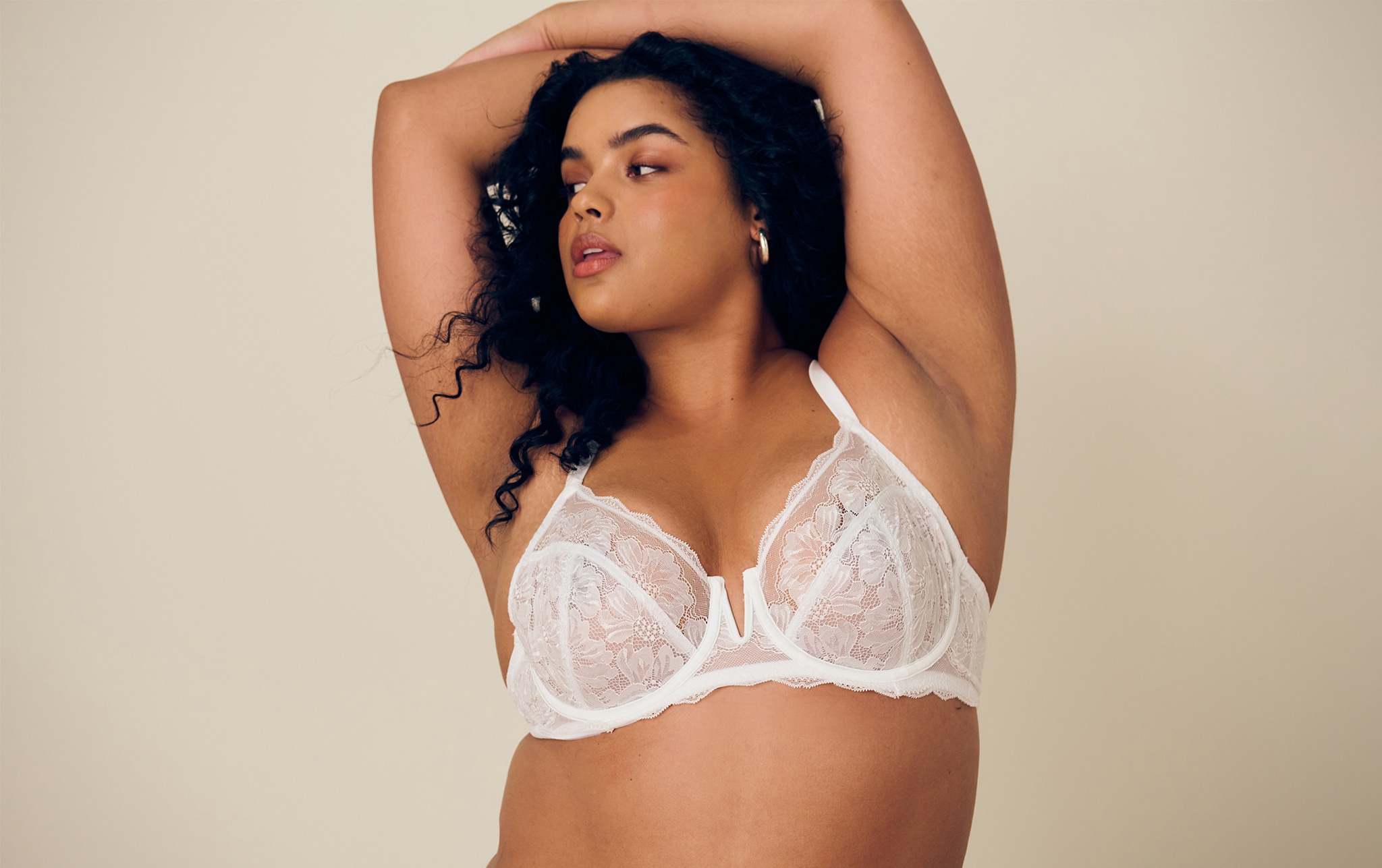 Model wears white bra with lace detail