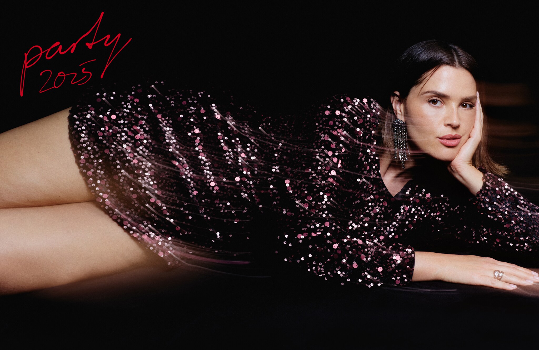 Model wears black and pink sequinned dress