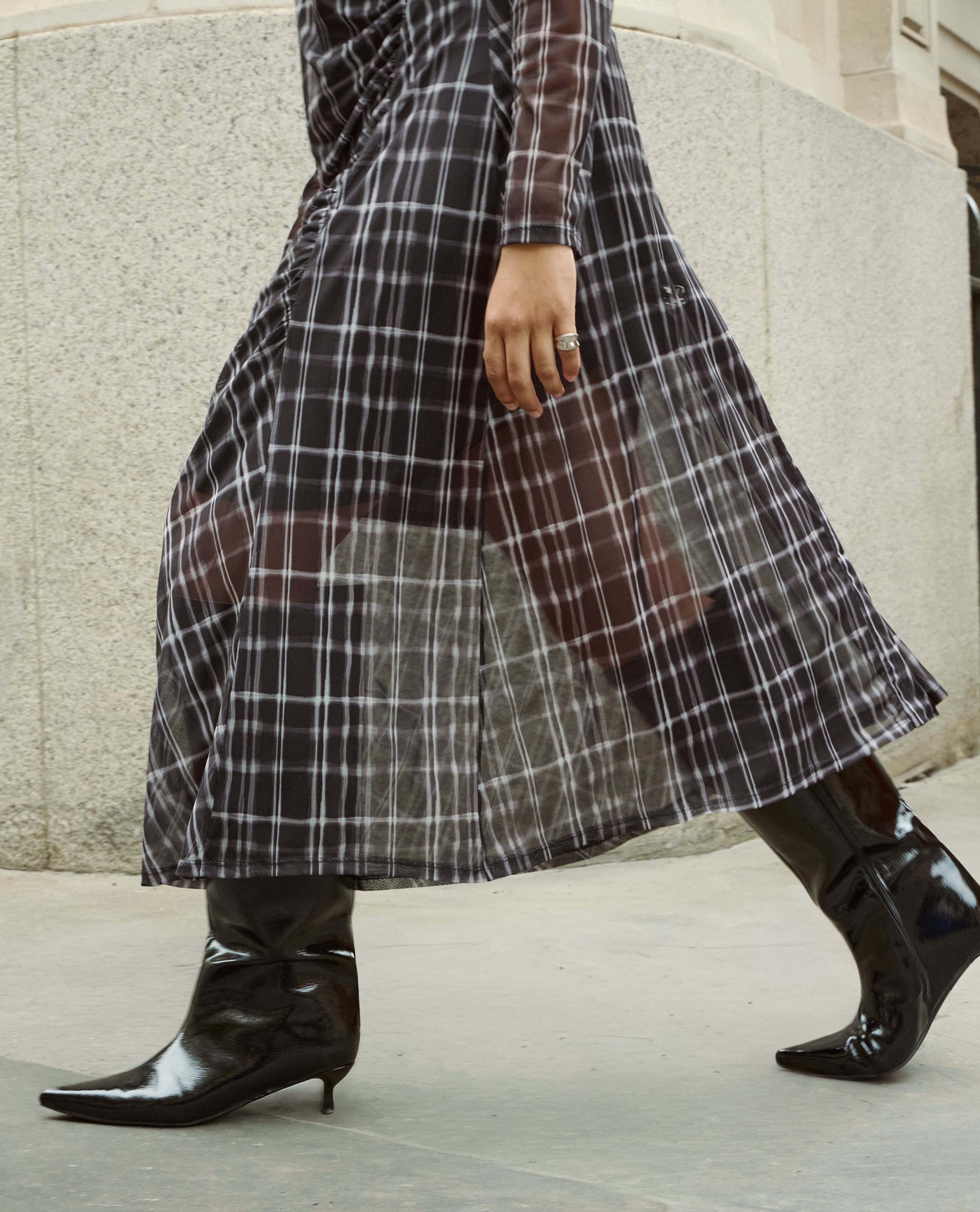 Model wears high leg patent black boots