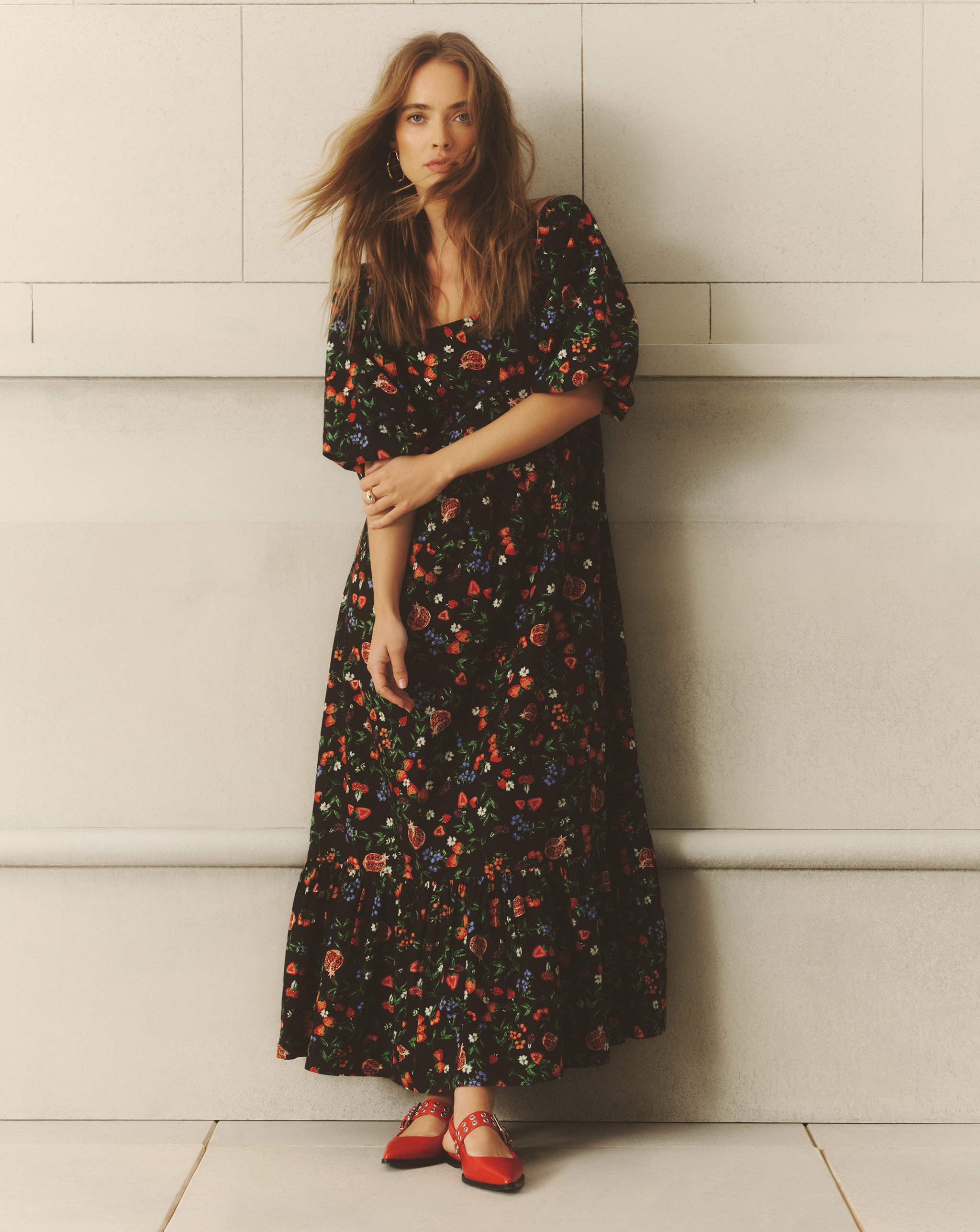 Model wears black floral print dress