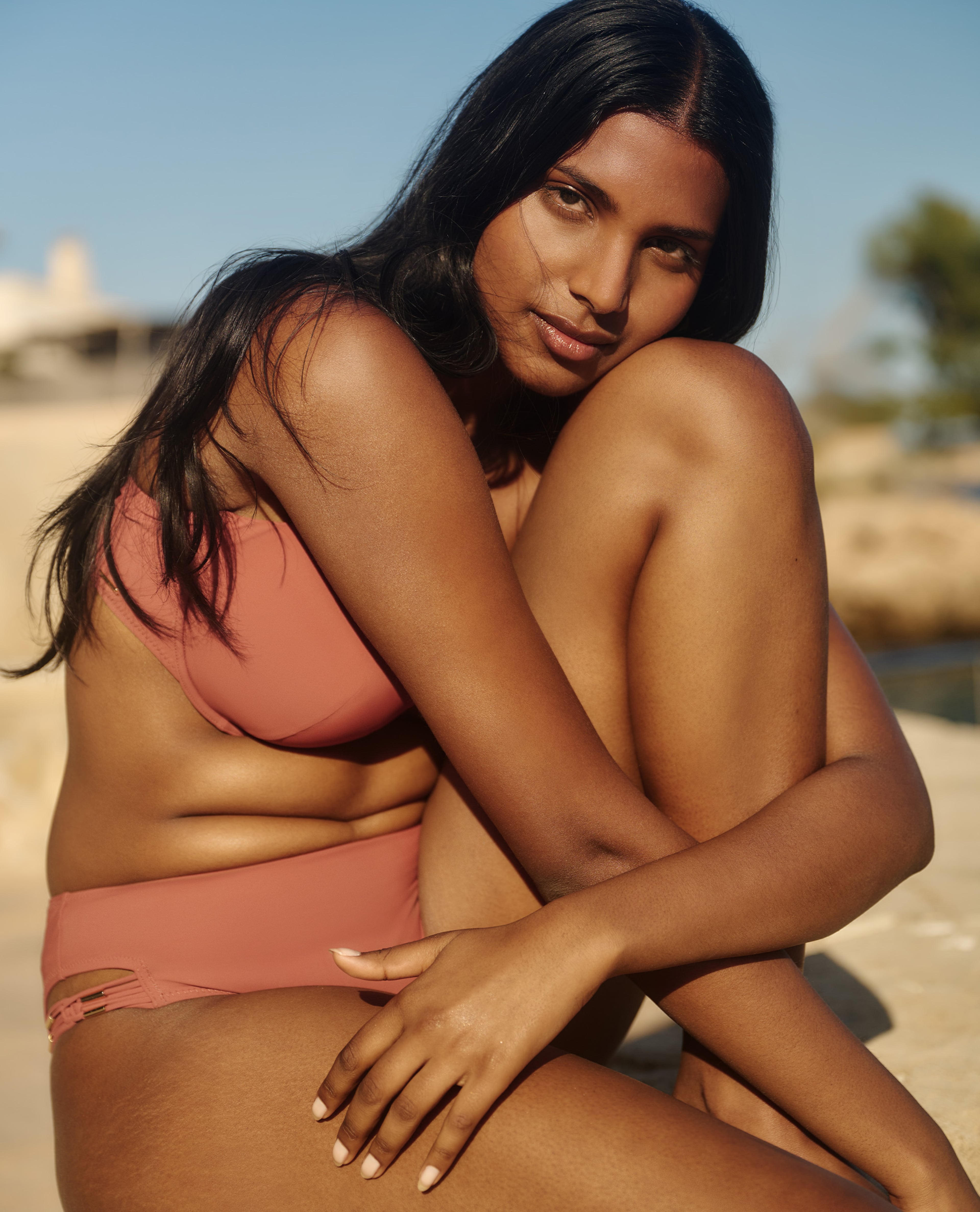 model wearing swimsuit sat on the wall