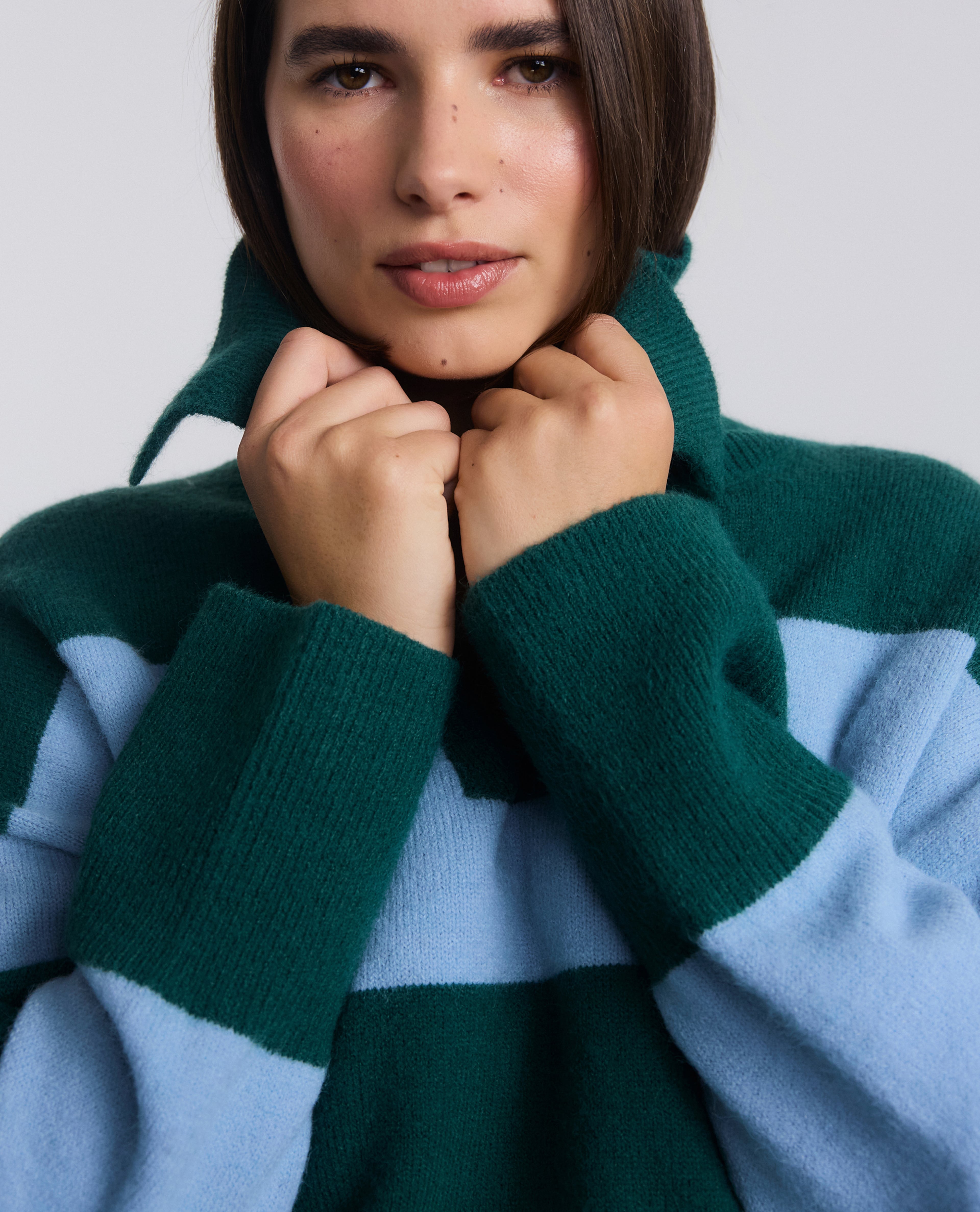 Model wears green and blue striped knit