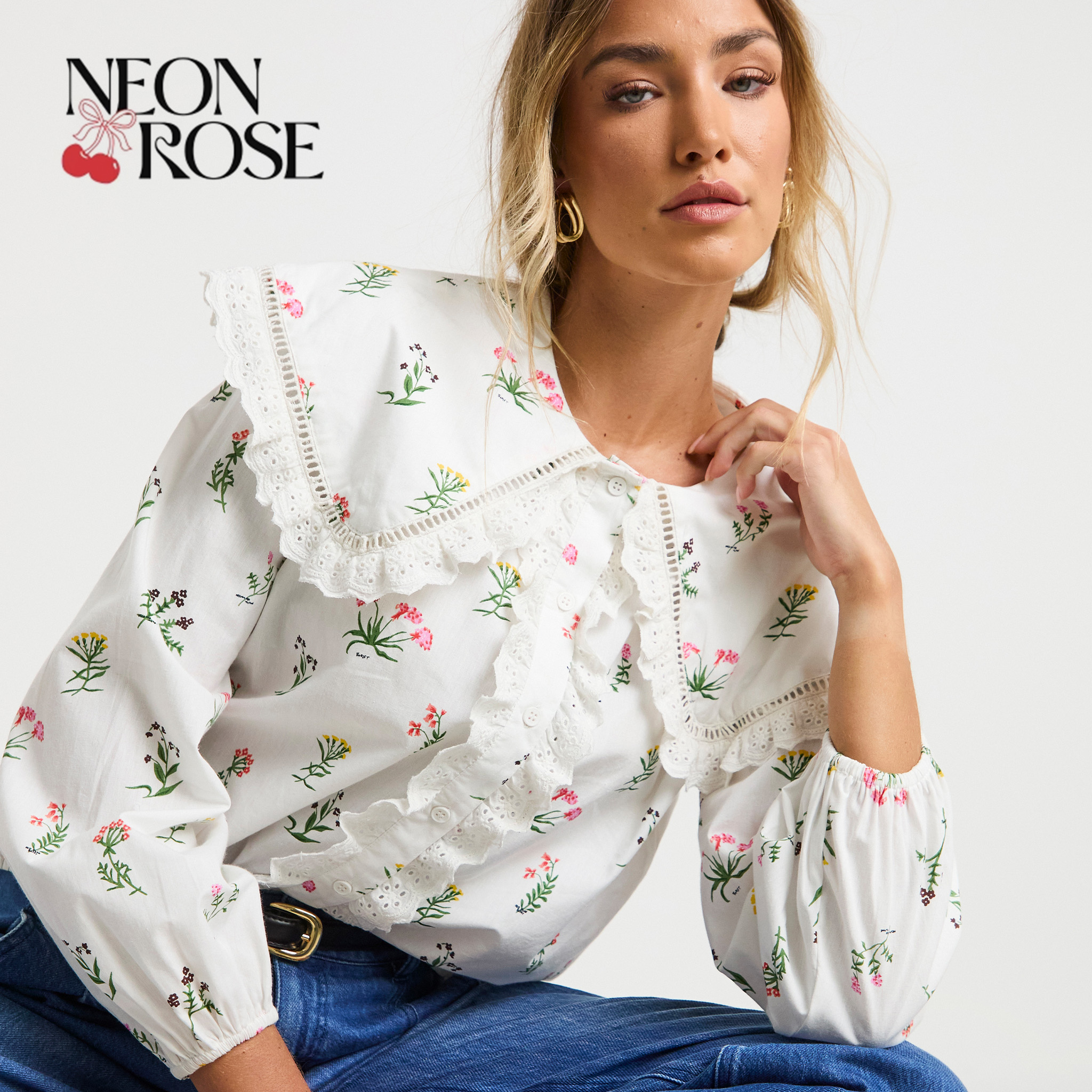 Neon rose model wearing white flowered top