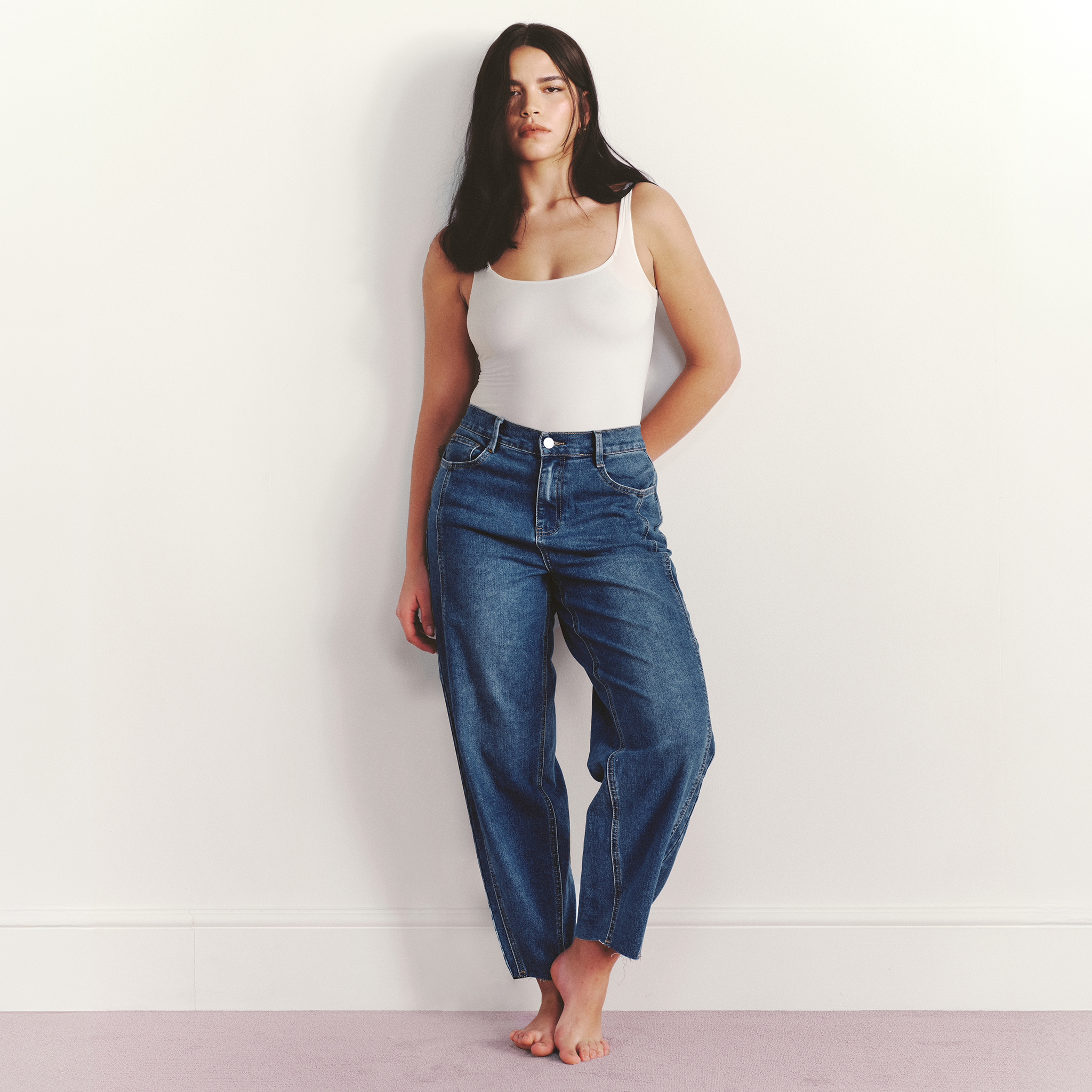 Model wears barrel jeans in mid blue