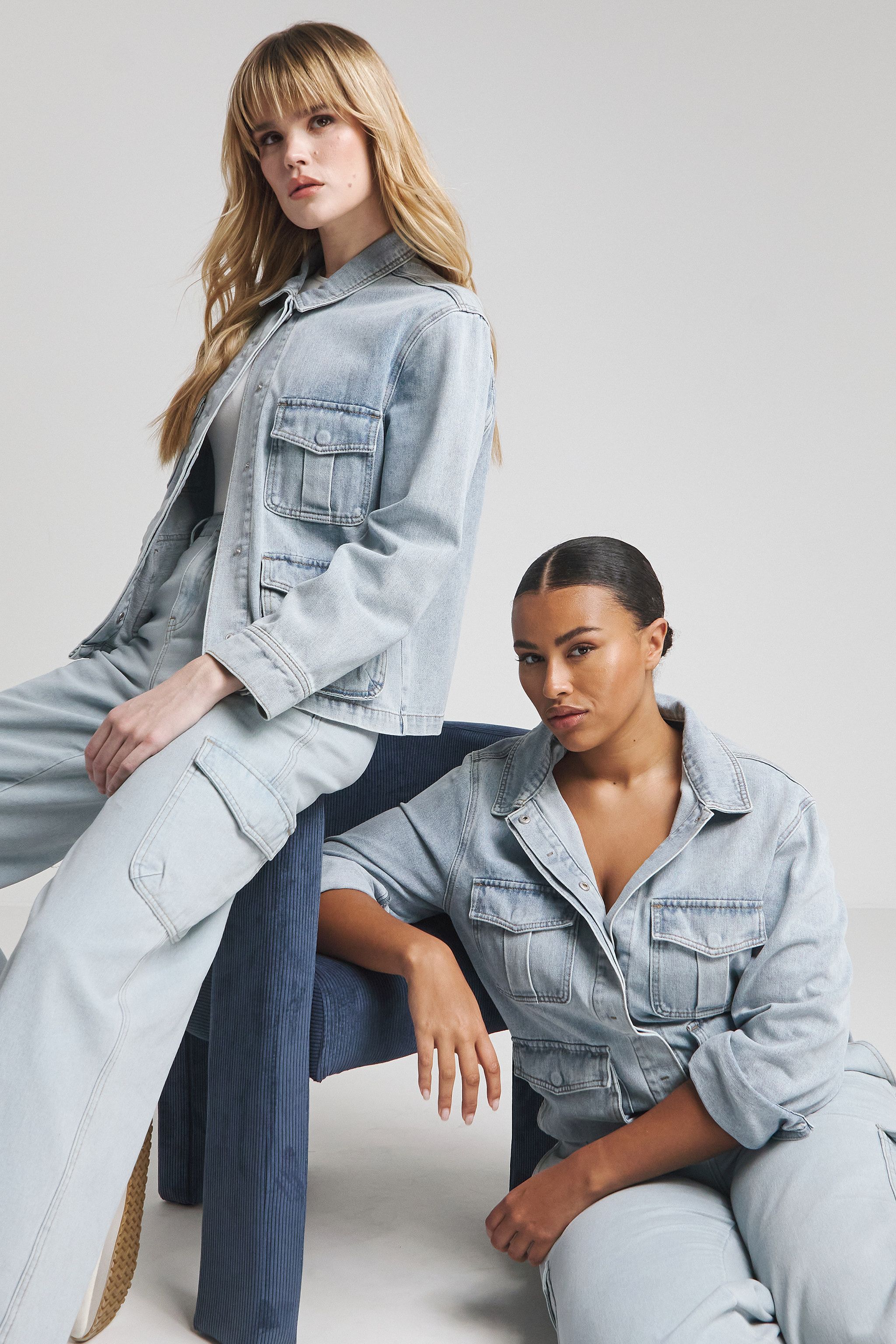 Two models wear the cargo denim jacket and jeans