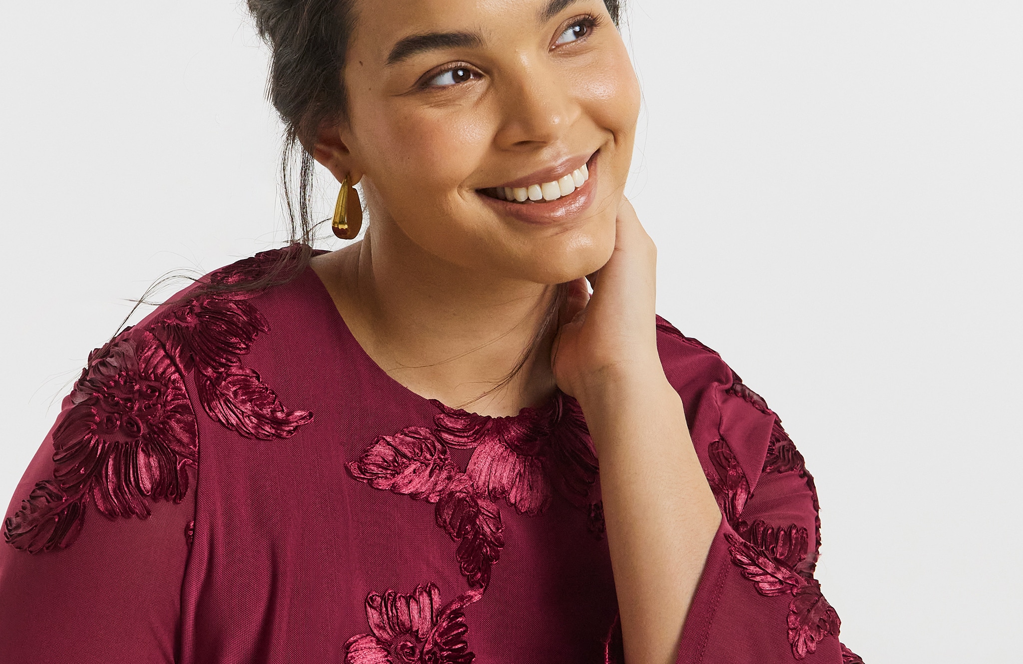 Model wears earrings  had dark red top