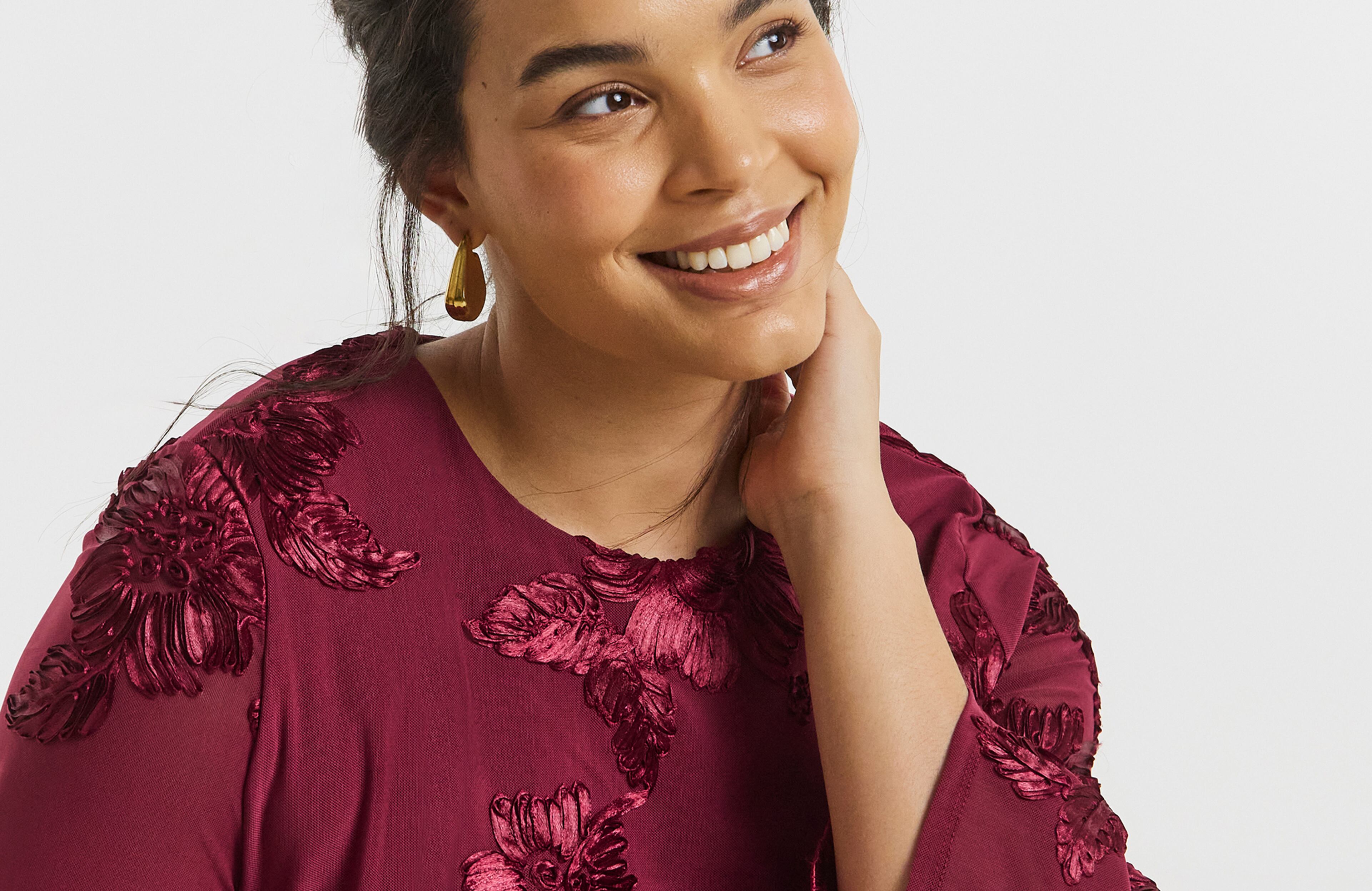 Model wears earrings  had dark red top