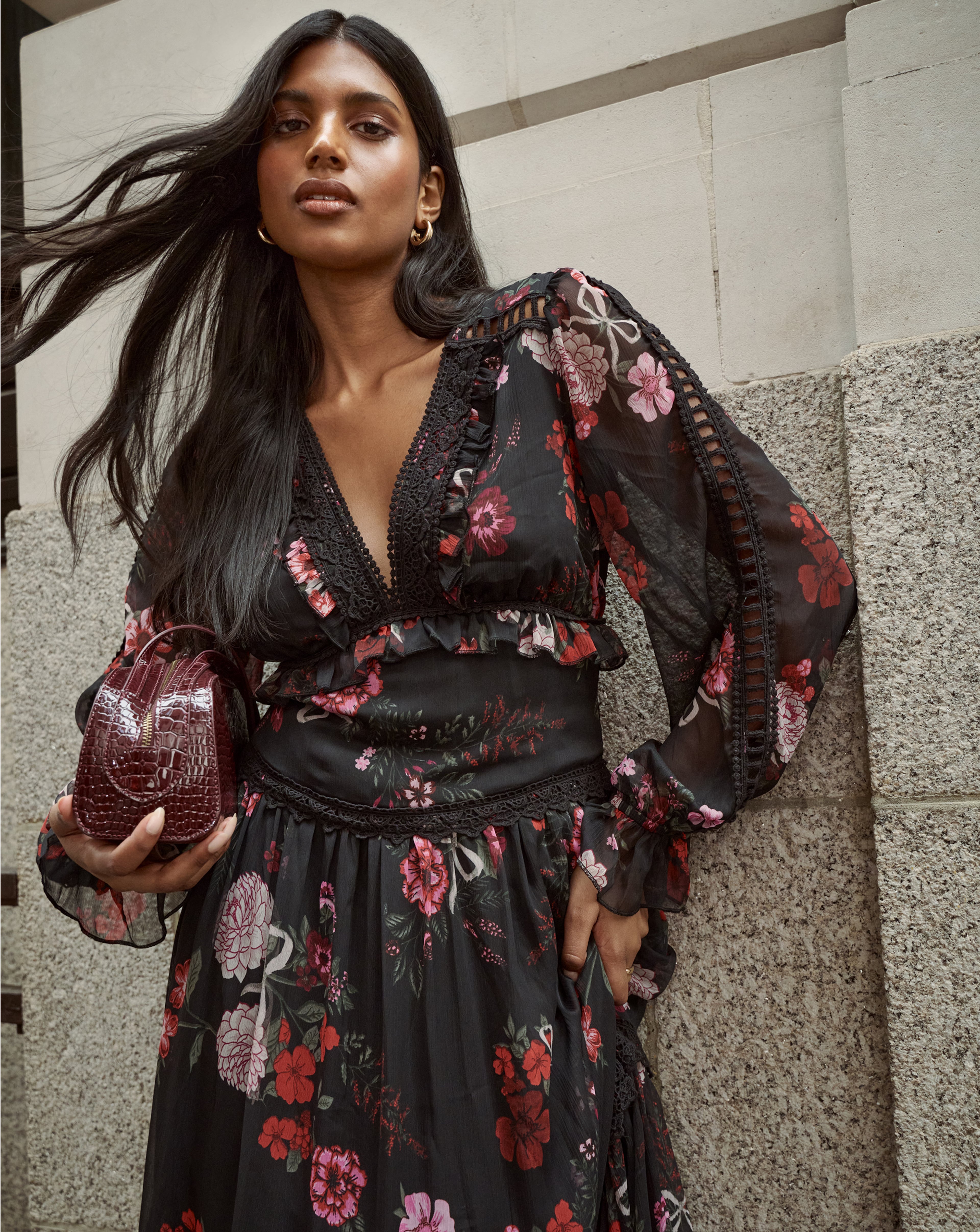 Model wears black floral dress