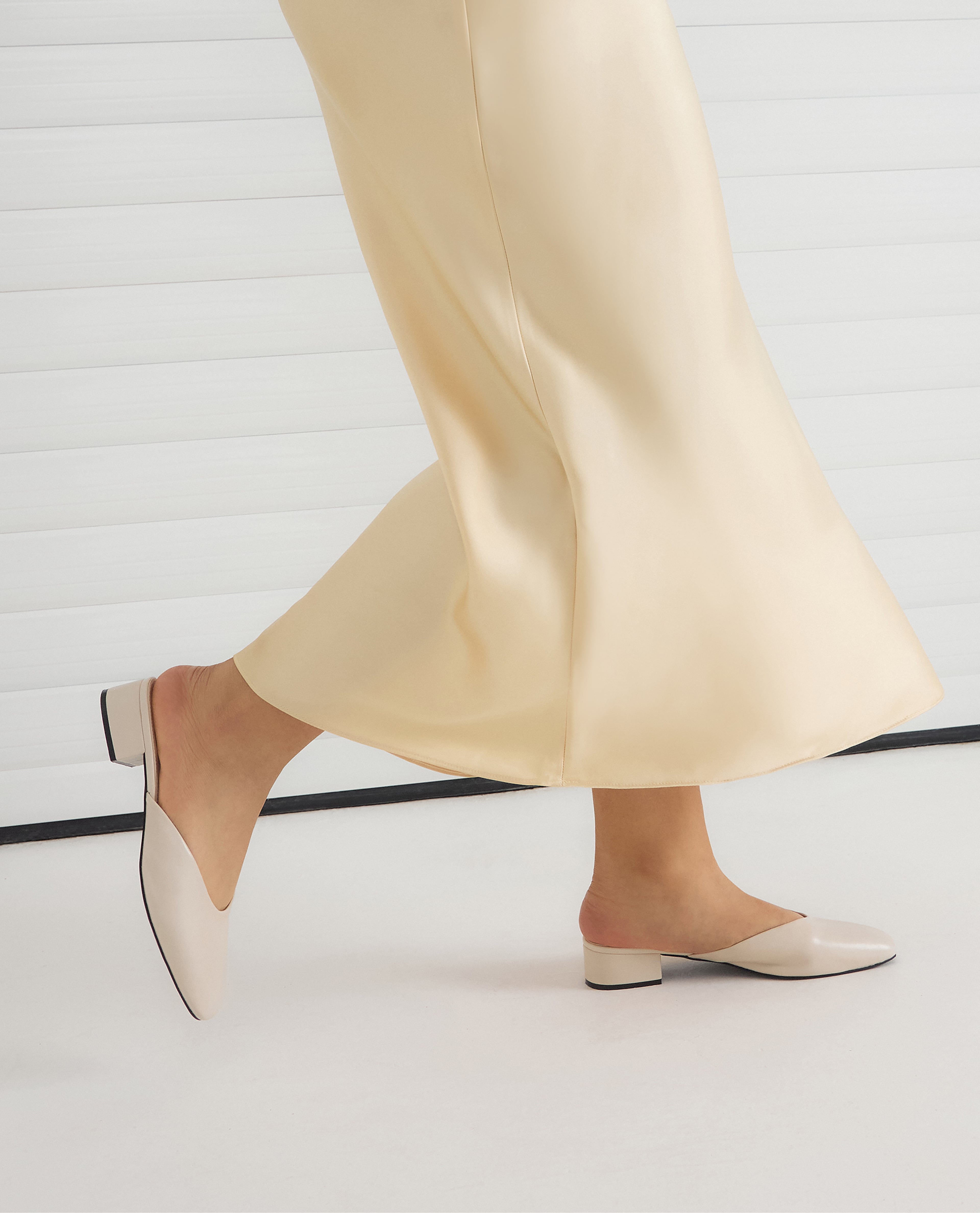 Model wers mule shoes in off-white