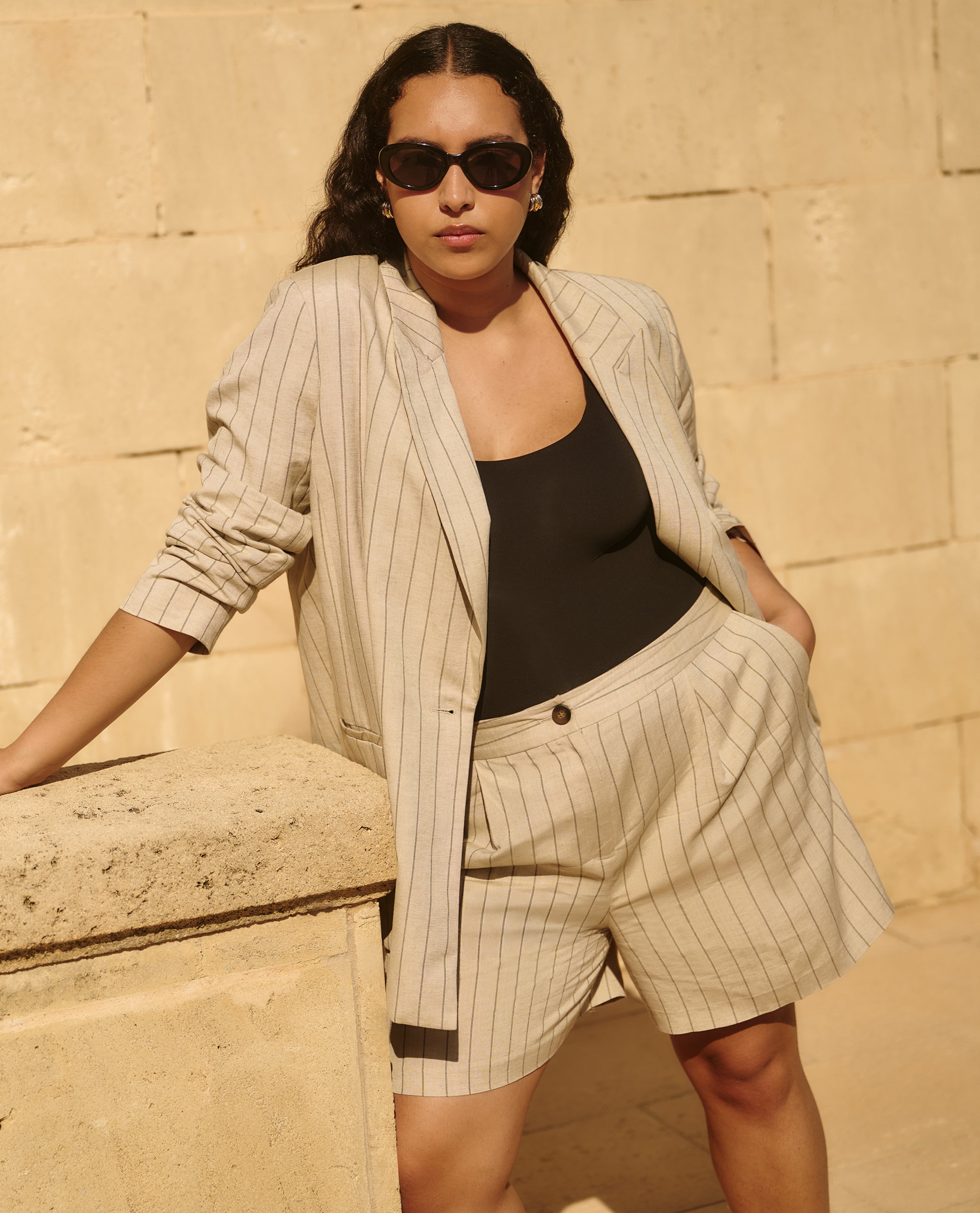 Model wearing beige matching jacket and shorts