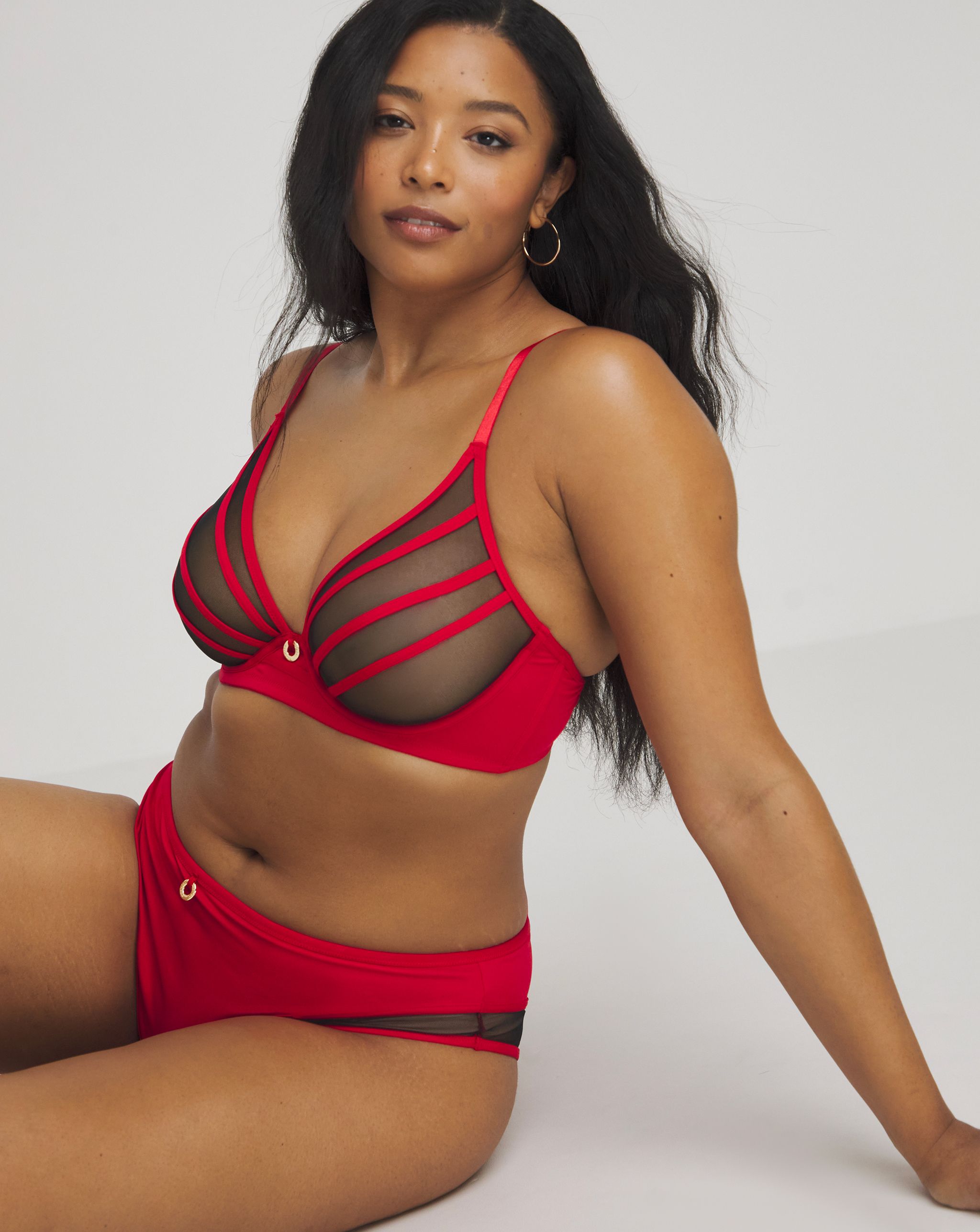 Model wearing a black an red bra and knickers