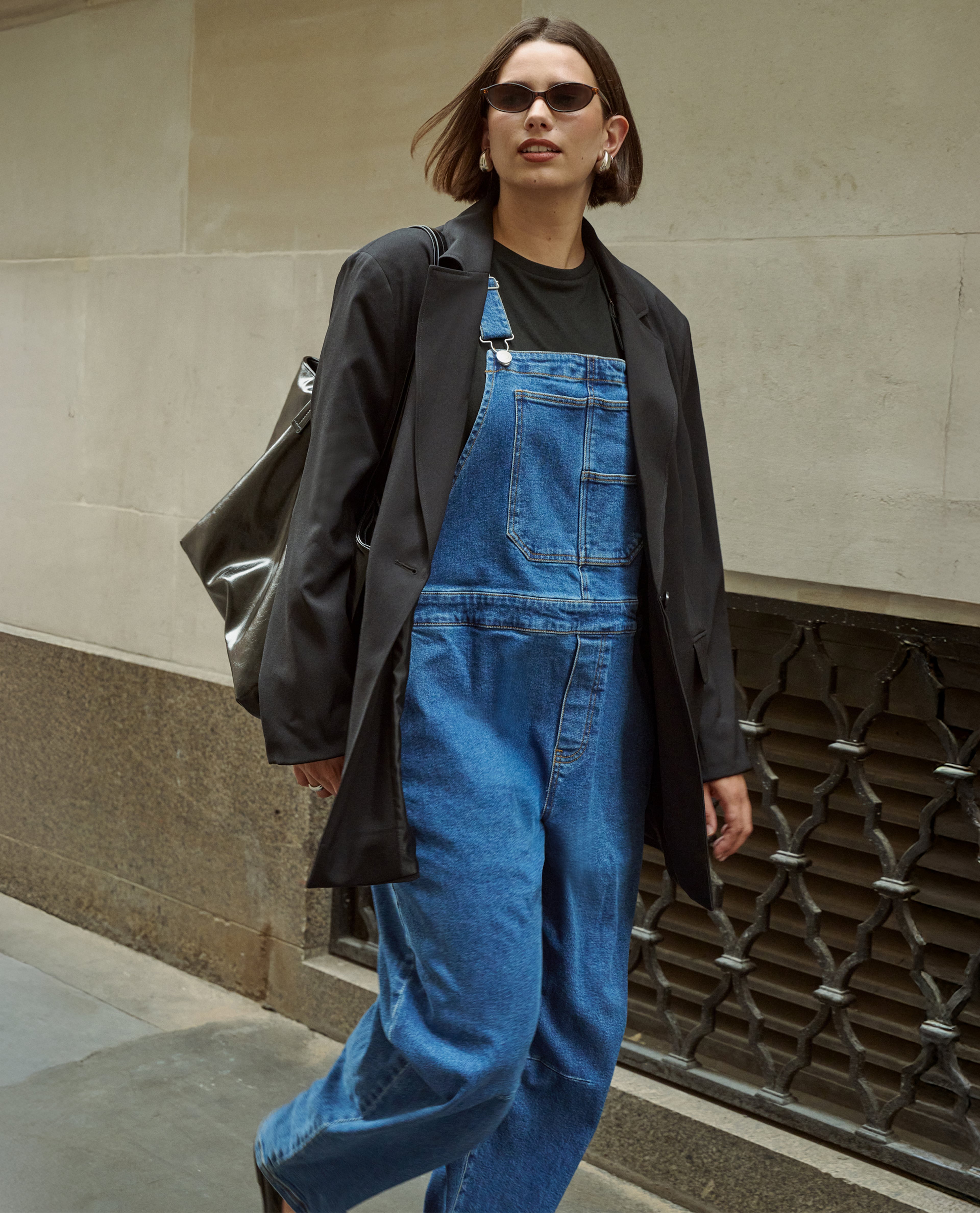 Model wears denim dungarees with jacket