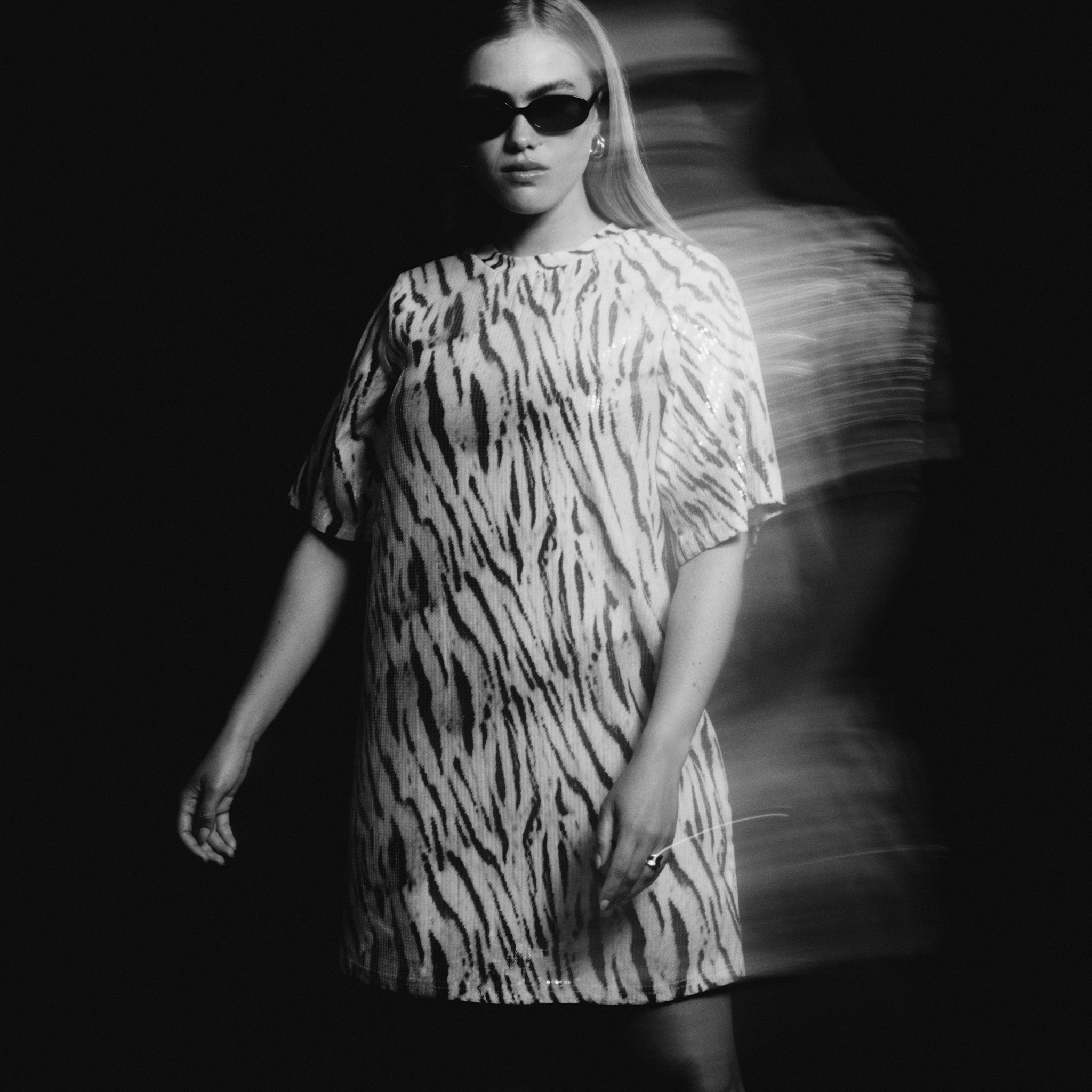 Model is wearing a black and white dress.