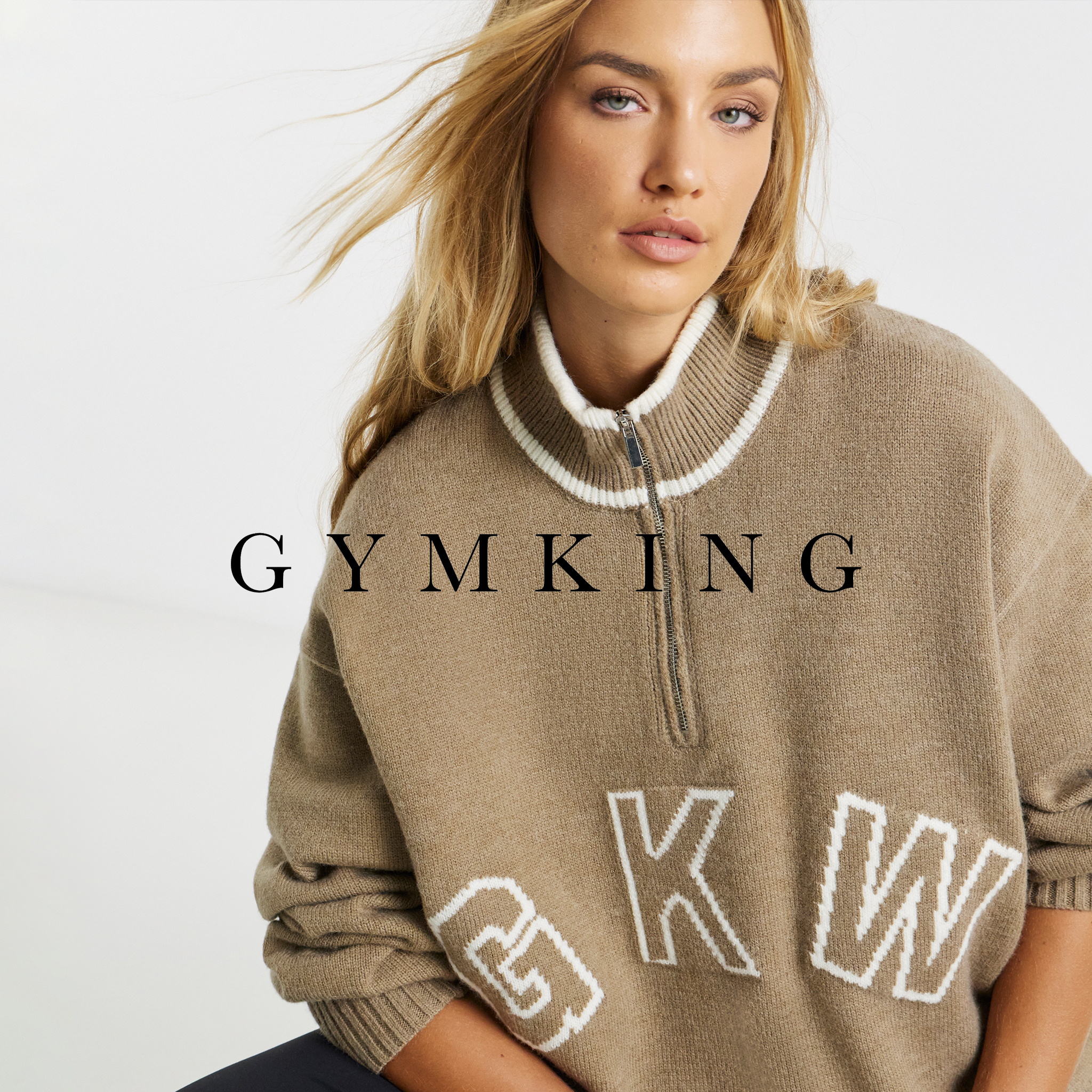 Model is wearing a Gym King Restore 1/4 Zip Knit with initials GKW on the front.
