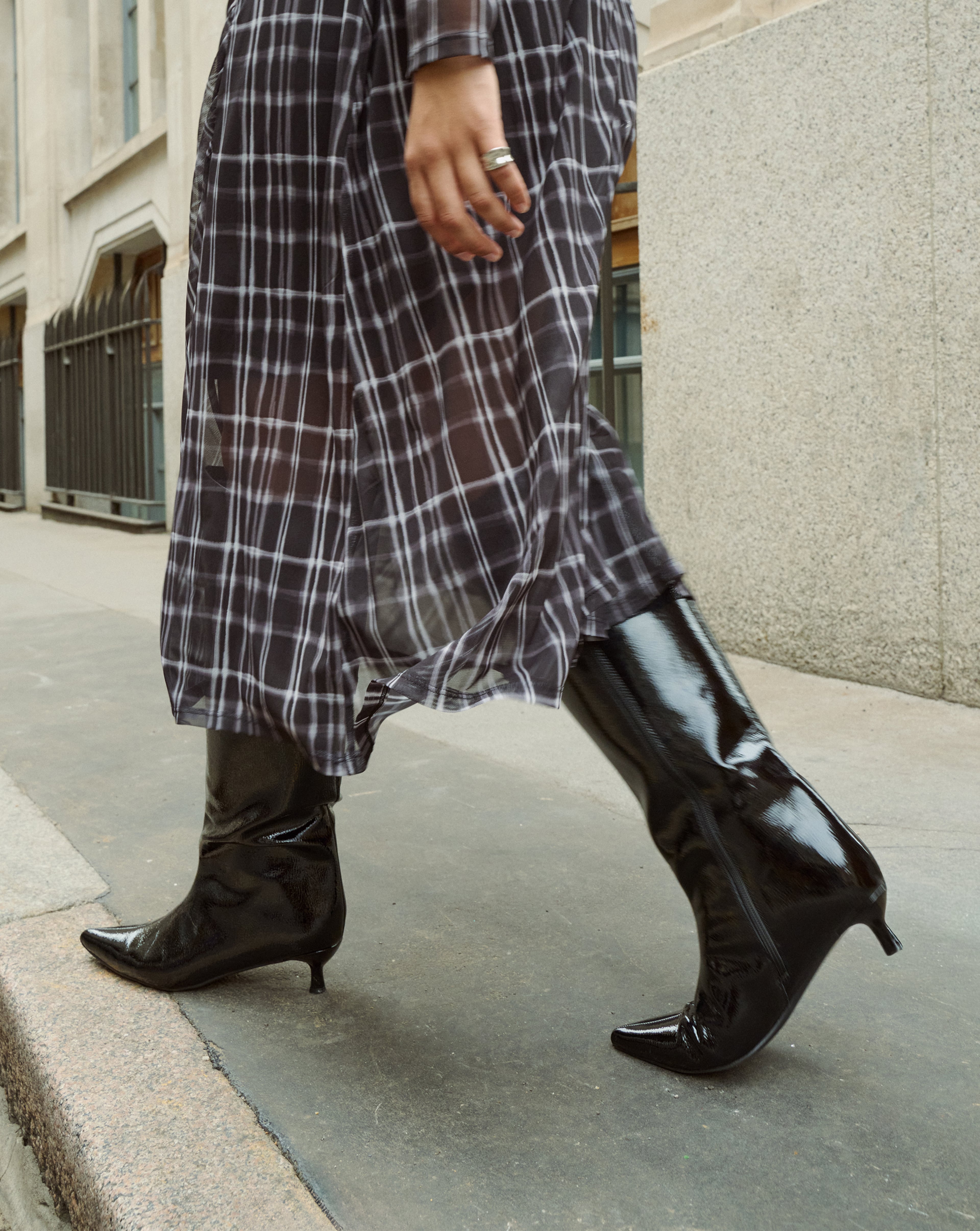Model wears patent black high boots