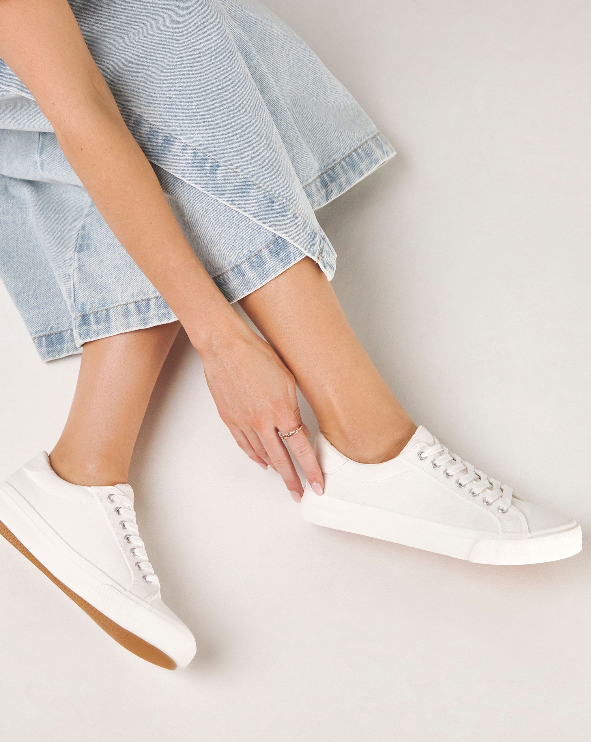 Model is wearing a pair of white Busselton lace up leisure pumps