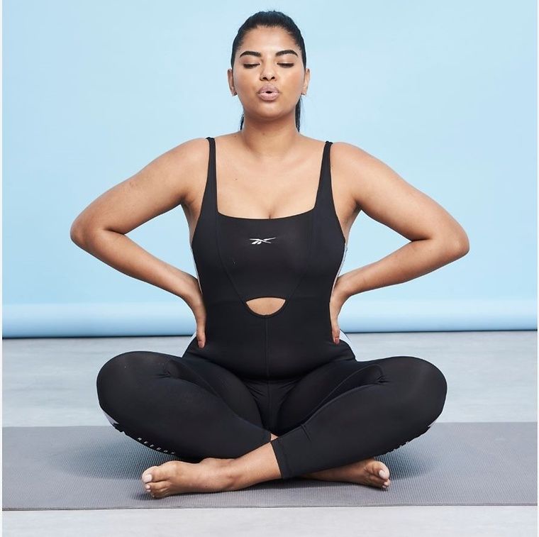 Model doing yoga wearing black lycra leggings and top