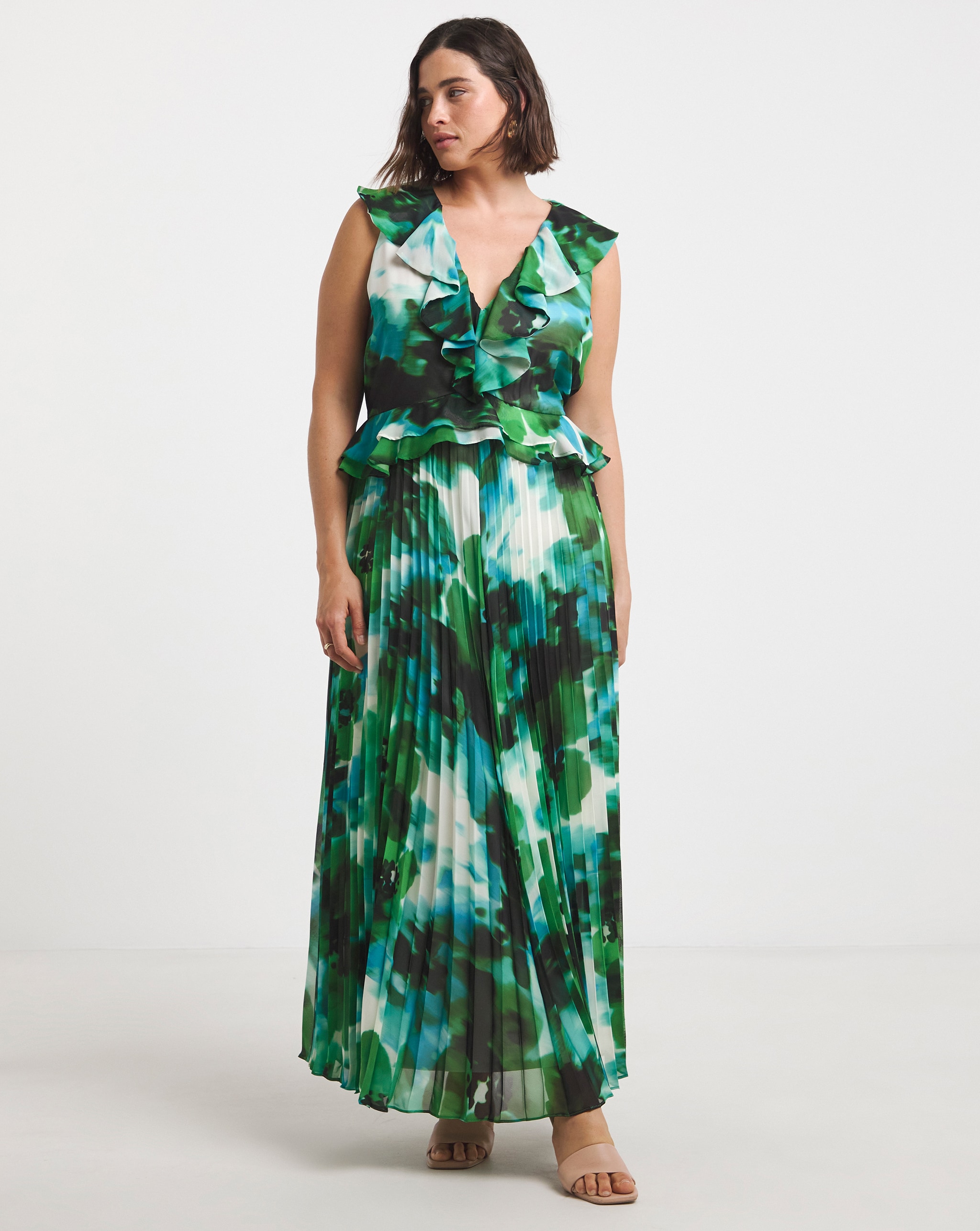 Model is wearing a Joanna Hope green floral ruffle pleated dress